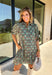 Embrace the beauty of the season in this charming dress from Entro. Featuring a gorgeous floral print in shades of hunter green, muted green, peach, and brown, this feminine dress is perfect for everything from weekend brunches to seasonal celebrations. The button-front design and flattering neckline create a timeless silhouette, while the ¾ puff sleeves with delicate tie details add a playful touch. 