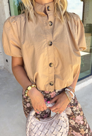 Simple, polished, and effortlessly chic, this tan button down top is a staple you'll wear all fall long. Crafted from breathable cotton, this timeless top features a modern bubble hem that creates a flattering silhouette with little effort. The band collar and button front add a tailored touch, while the short puff sleeves bring just the right amount of feminine charm. 