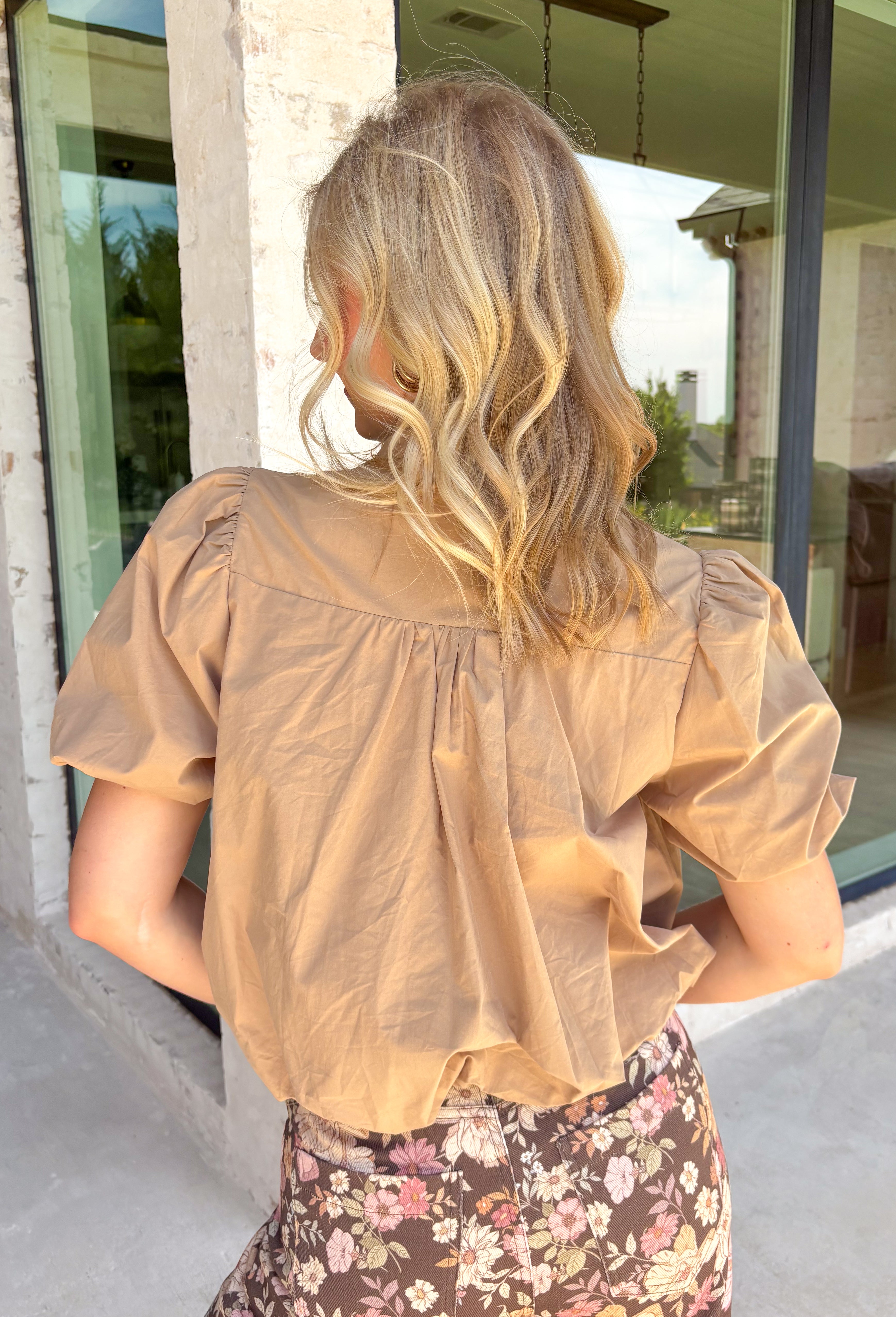 Simple, polished, and effortlessly chic, this tan button down top is a staple you'll wear all fall long. Crafted from breathable cotton, this timeless top features a modern bubble hem that creates a flattering silhouette with little effort. The band collar and button front add a tailored touch, while the short puff sleeves bring just the right amount of feminine charm. 