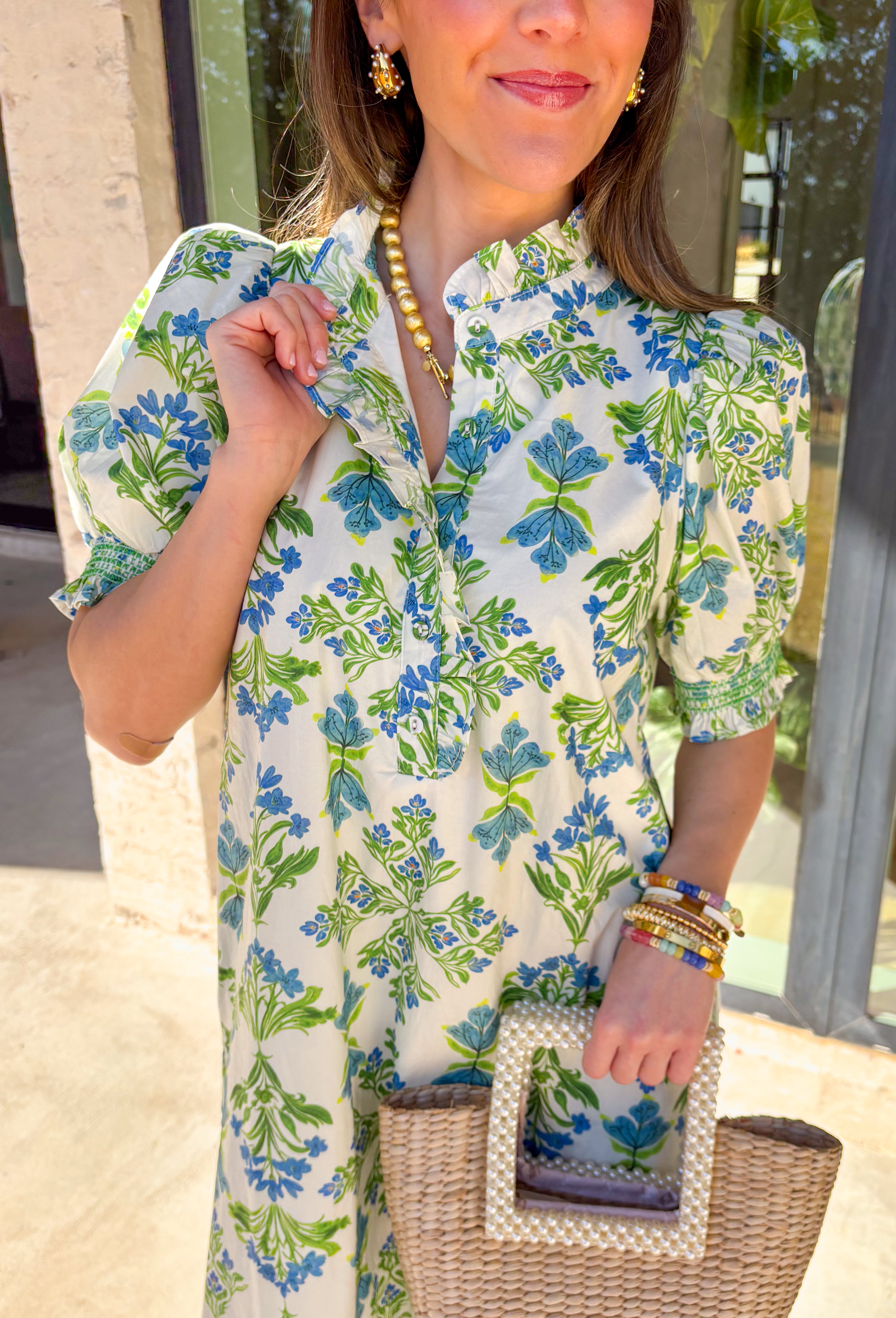 Fresh, flowy, and full of spring charm, this cream midi dress by Entro is an easy favorite for the season. Featuring a beautiful botanical print in soft green and blue hues, it brings a calm, airy feel that’s perfect for warmer days. The ruffled trim at the collar adds a sweet touch, while the button-front detail keeps the look classic and effortless. Finished with short puff sleeves, smocked cuffs, side pockets, and a full lining, this dress blends comfort and pretty details in the best way.