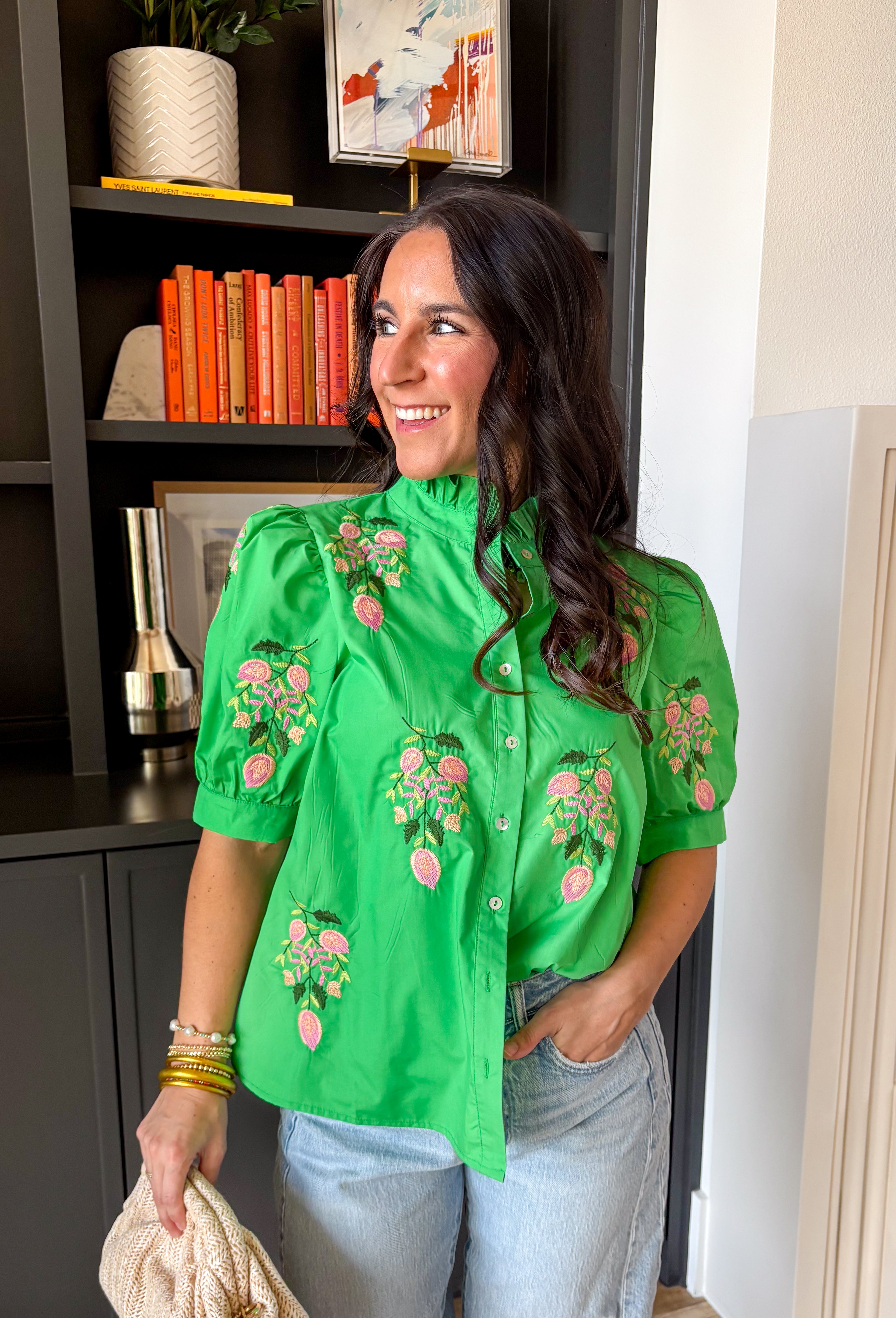 Bright, cheerful, and full of spring charm, this kelly green short sleeve top by Entro is such a fun way to add a pop of color to your everyday lineup. The pink and green floral embroidery along the top gives it that extra-special touch, while the button-down front keeps it classic and easy to style. Finished with puff sleeves and a sweet ruffle neckline, this top feels feminine and playful without being too fussy.
