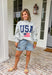 This grey reversible pullover is the ultimate cozy-meets-festive piece for your summer celebrations! Designed with two looks in one, one side features “USA” in navy with a flag design, while the other side is fleece lined with “America” in blue for a softer, cozier feel. The mock neck adds an elevated touch, making it perfect for those cooler summer nights—think fireworks, lake evenings, or early morning coffee runs. It’s an easy throw-on layer that still feels fun and patriotic. 