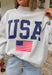 This grey reversible pullover is the ultimate cozy-meets-festive piece for your summer celebrations! Designed with two looks in one, one side features “USA” in navy with a flag design, while the other side is fleece lined with “America” in blue for a softer, cozier feel. The mock neck adds an elevated touch, making it perfect for those cooler summer nights—think fireworks, lake evenings, or early morning coffee runs. It’s an easy throw-on layer that still feels fun and patriotic. 