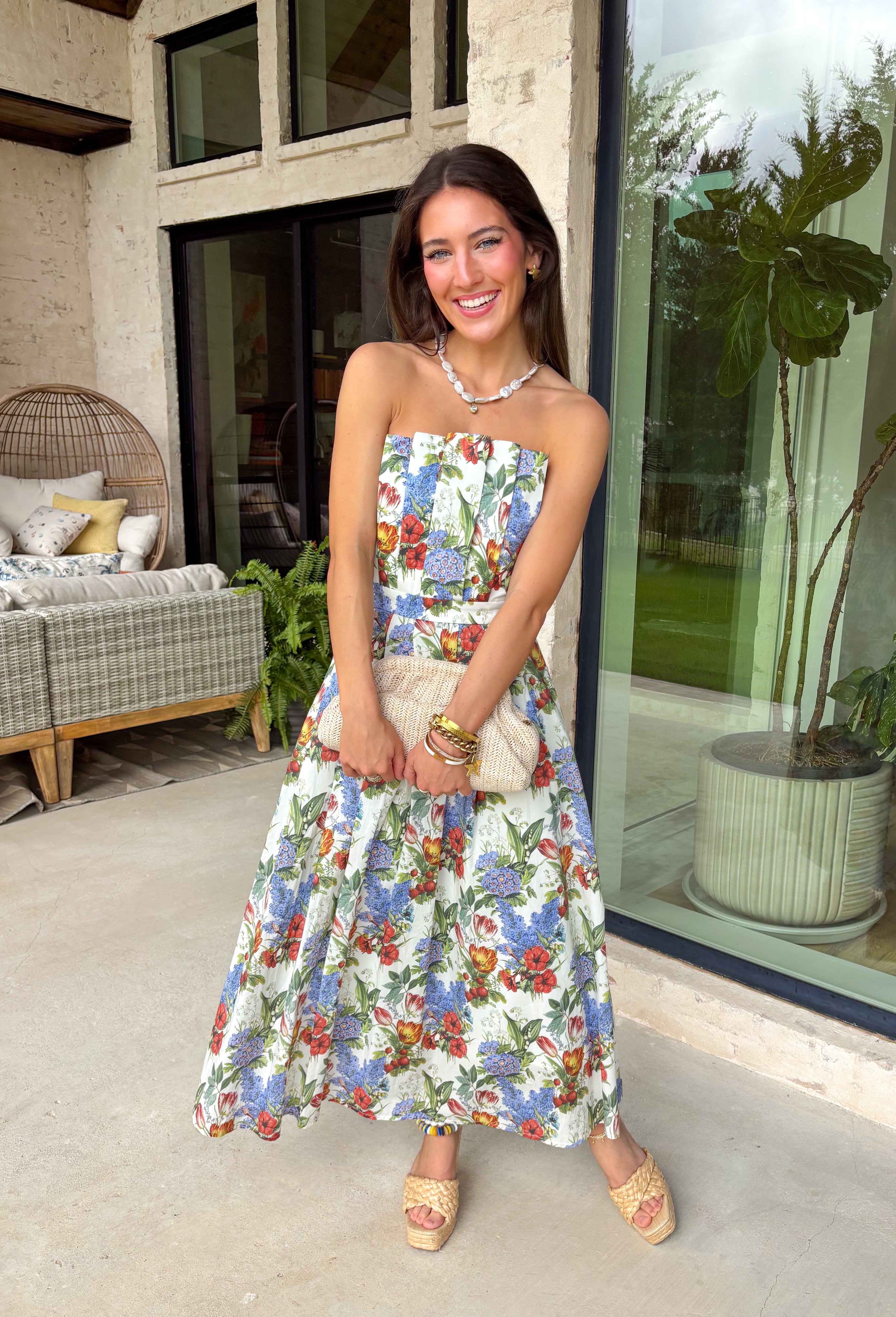 Romantic and effortlessly graceful, this cream strapless midi dress by Entro is made for special warm weather moments. Featuring a beautiful floral print with strawberries throughout, it’s designed with pleated detailing along the chest for a flattering shape and a smocked back for added comfort and flexibility. Side pockets add a practical touch, while the fully lined cotton fabric keeps it light and breathable. This will quickly become a favorite!