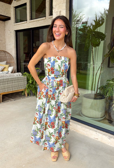 Romantic and effortlessly graceful, this cream strapless midi dress by Entro is made for special warm weather moments. Featuring a beautiful floral print with strawberries throughout, it’s designed with pleated detailing along the chest for a flattering shape and a smocked back for added comfort and flexibility. Side pockets add a practical touch, while the fully lined cotton fabric keeps it light and breathable. This will quickly become a favorite!