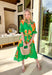 This green midi dress is a total spring showstopper thanks to its bold floral print in sunny orange and yellow! The vibrant blooms pop beautifully against the fresh green background, giving you that cheerful, can’t-miss-it kind of look (in the best way). The flattering v-neckline and matching self-tie waist create an easy, defined shape, while the elastic cuffs keep the sleeves comfy and effortless. Finished with side pockets and a full lining, this dress is ready for everything from brunch to spring events