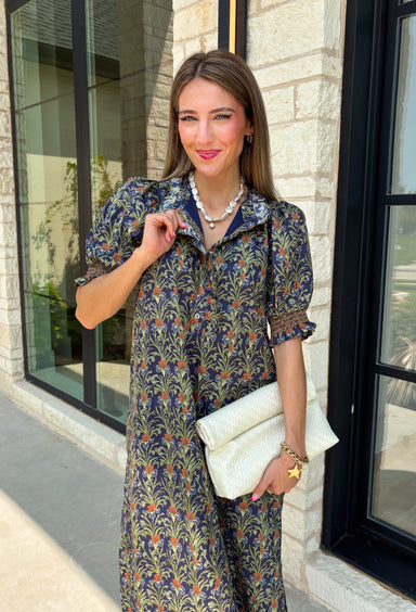 From weekend brunches to family gatherings, this floral midi dress is one you'll be reaching for all season long. Designed in a soft ecru hue with a beautiful floral print, this feminine silhouette is elevated with delicate eyelet lace embroidery throughout for an extra touch of texture and charm. The ruffle neckline, puff sleeves, and tiered ruffle hem create a timeless look, while side pockets make it as practical as it is pretty. 