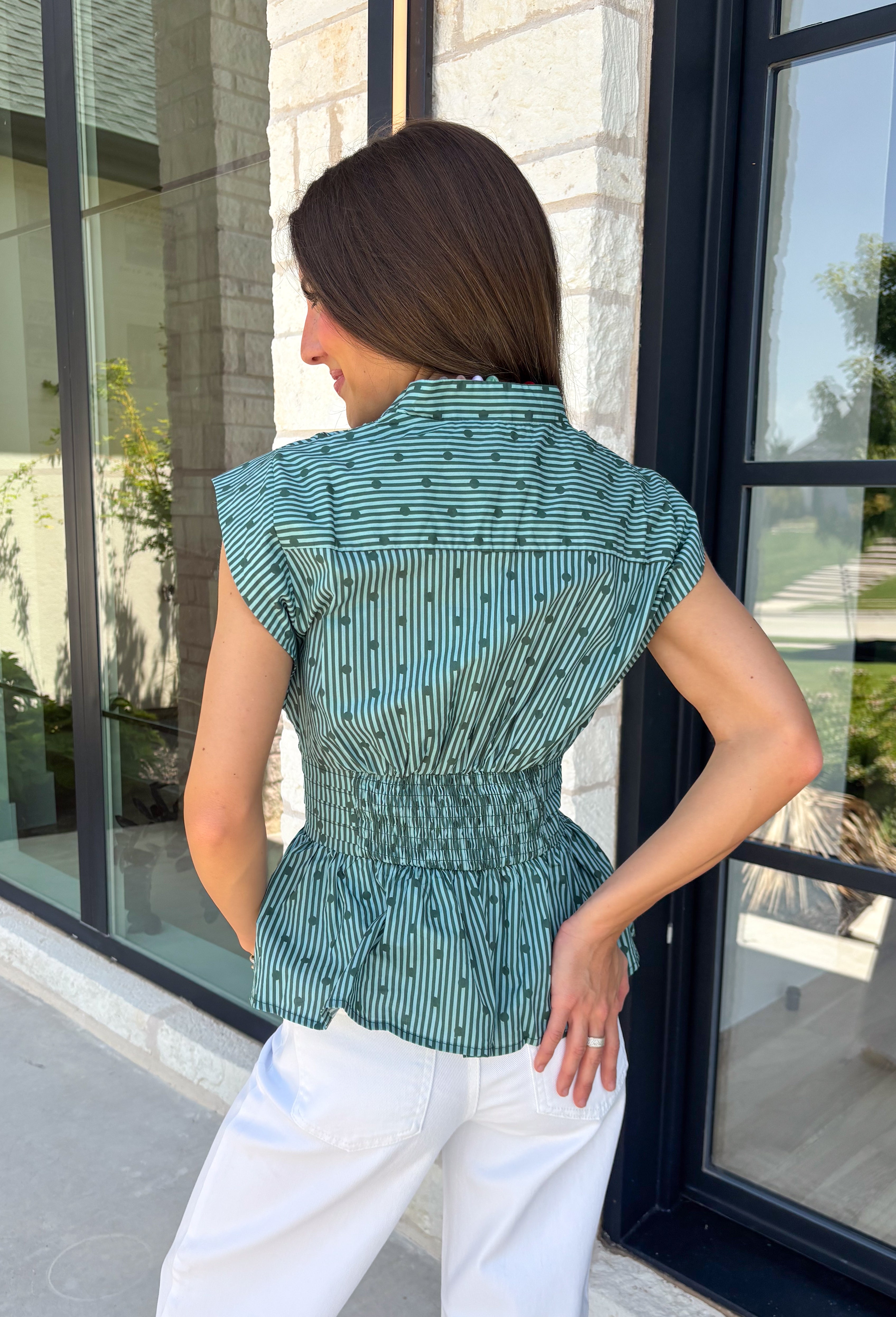 Classic stripes and flattering details make this sleeveless blouse an effortless favorite for fall! Featuring rich hunter green and light blue stripes, and hunter green polka dots, this timeless top is designed with a flattering v-neckline and an adjustable self-tie waist that creates a beautifully defined silhouette. The button front adds a polished finish, while the smocked elastic back offers all-day comfort and the perfect fit. 