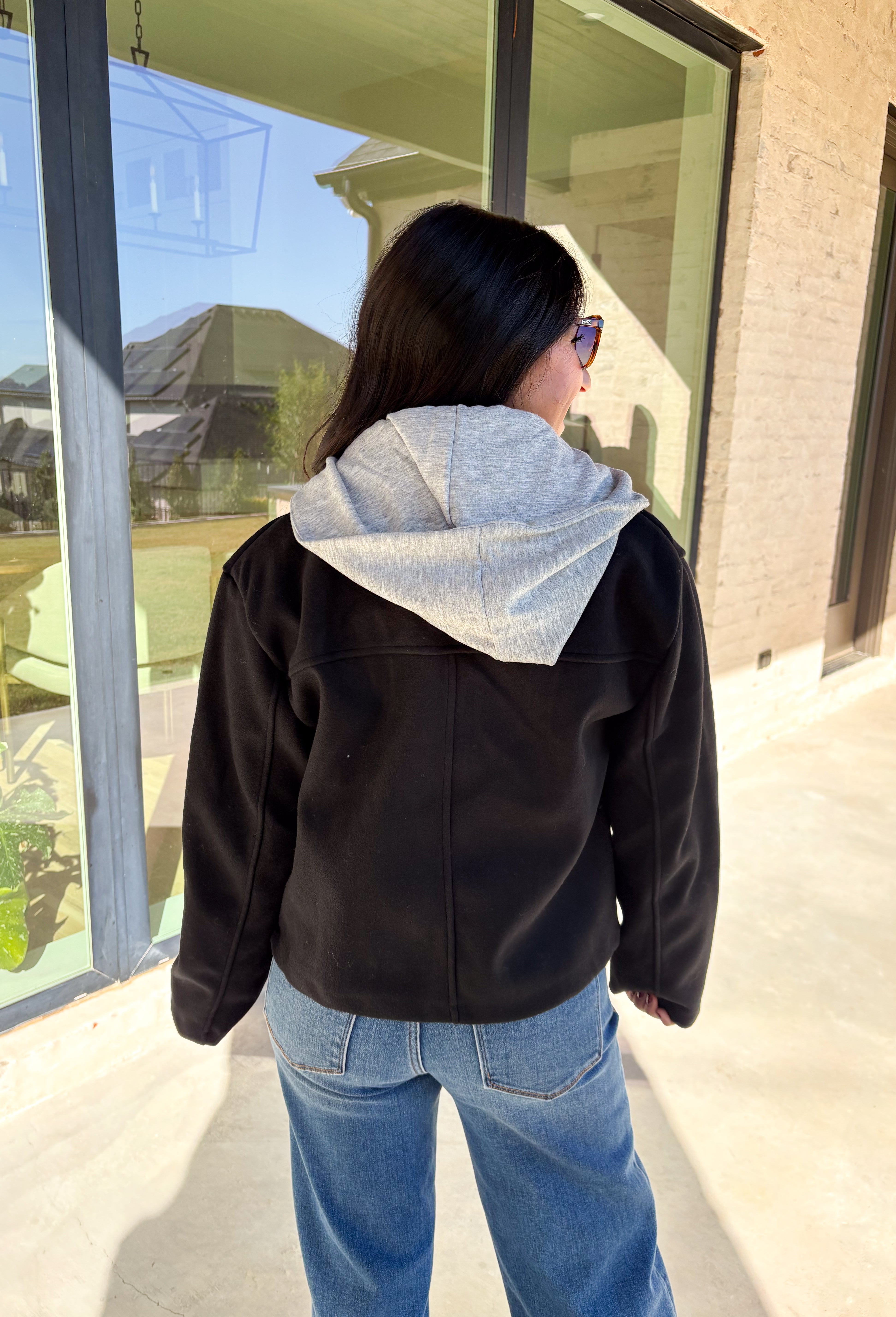 Layered and cozy, this cropped peacoat jacket by Iris brings together the best of both worlds—a timeless wool-inspired peacoat look with a built-in gray hoodie insert for casual comfort. The double-breasted front adds classic structure, while the soft gray hood gives it a relaxed, everyday twist. With side pockets and a cropped length, it’s the perfect piece for adding a cozy, layered touch to your winter outfits.