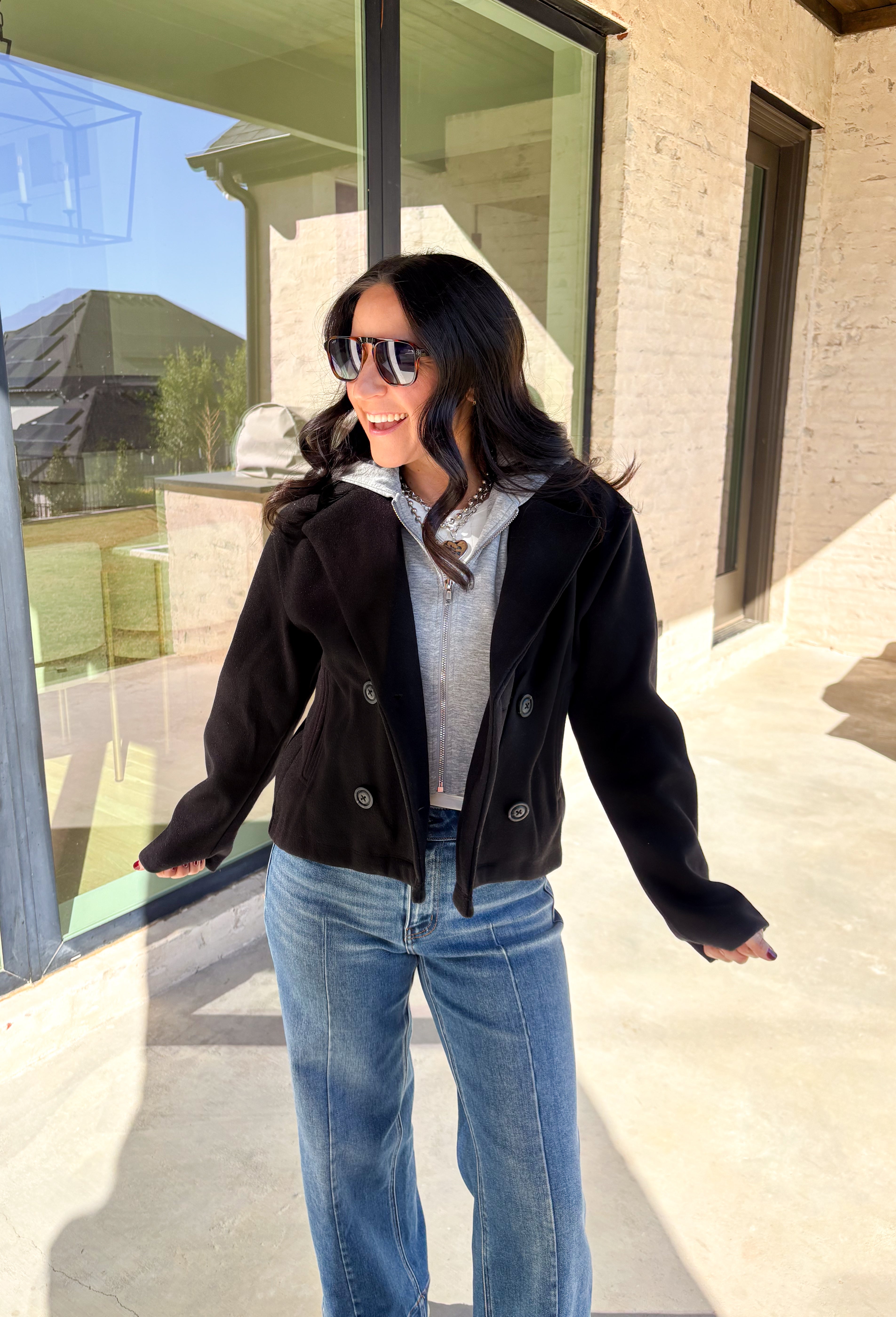 Layered and cozy, this cropped peacoat jacket by Iris brings together the best of both worlds—a timeless wool-inspired peacoat look with a built-in gray hoodie insert for casual comfort. The double-breasted front adds classic structure, while the soft gray hood gives it a relaxed, everyday twist. With side pockets and a cropped length, it’s the perfect piece for adding a cozy, layered touch to your winter outfits.