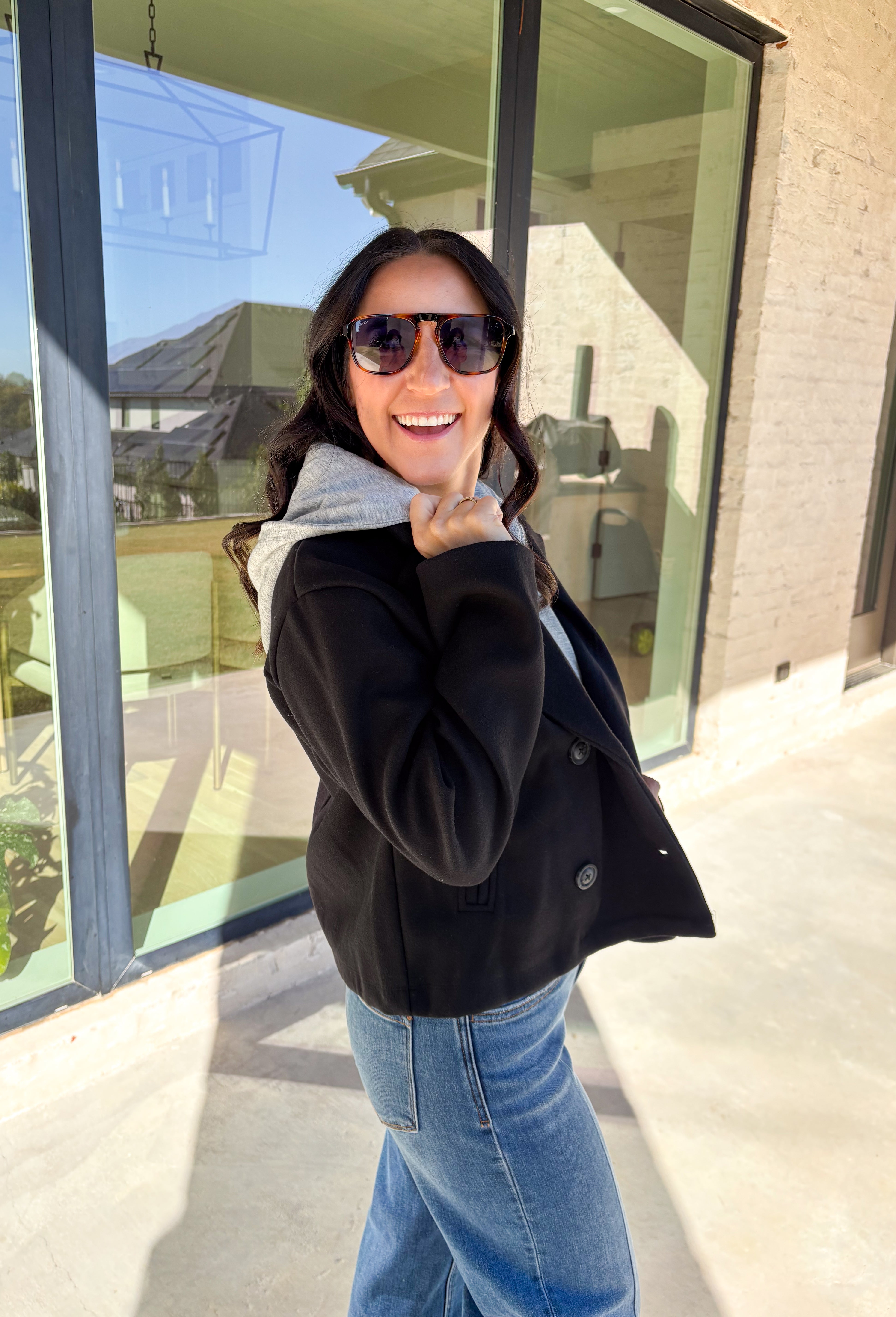 Layered and cozy, this cropped peacoat jacket by Iris brings together the best of both worlds—a timeless wool-inspired peacoat look with a built-in gray hoodie insert for casual comfort. The double-breasted front adds classic structure, while the soft gray hood gives it a relaxed, everyday twist. With side pockets and a cropped length, it’s the perfect piece for adding a cozy, layered touch to your winter outfits.