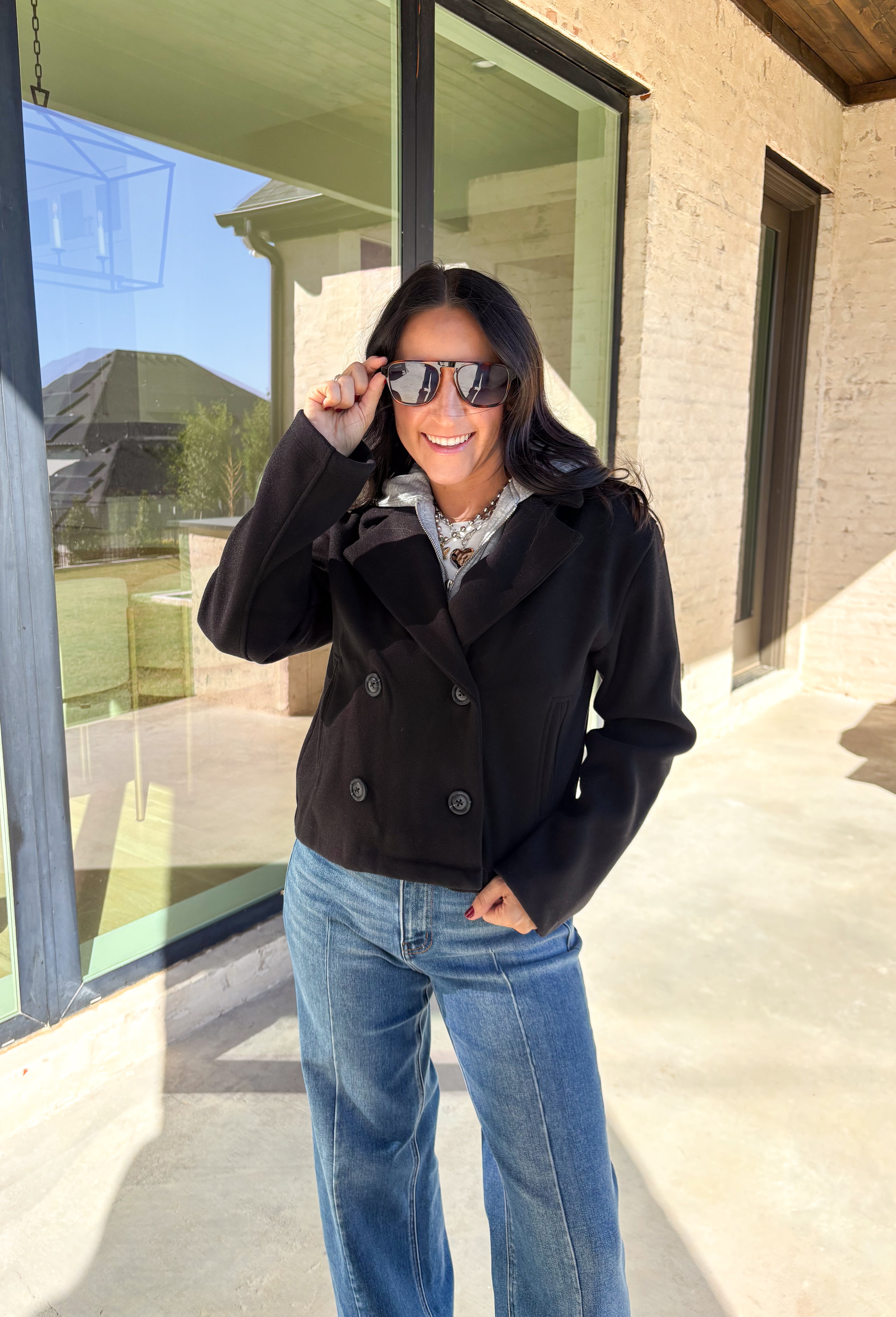 Layered and cozy, this cropped peacoat jacket by Iris brings together the best of both worlds—a timeless wool-inspired peacoat look with a built-in gray hoodie insert for casual comfort. The double-breasted front adds classic structure, while the soft gray hood gives it a relaxed, everyday twist. With side pockets and a cropped length, it’s the perfect piece for adding a cozy, layered touch to your winter outfits.