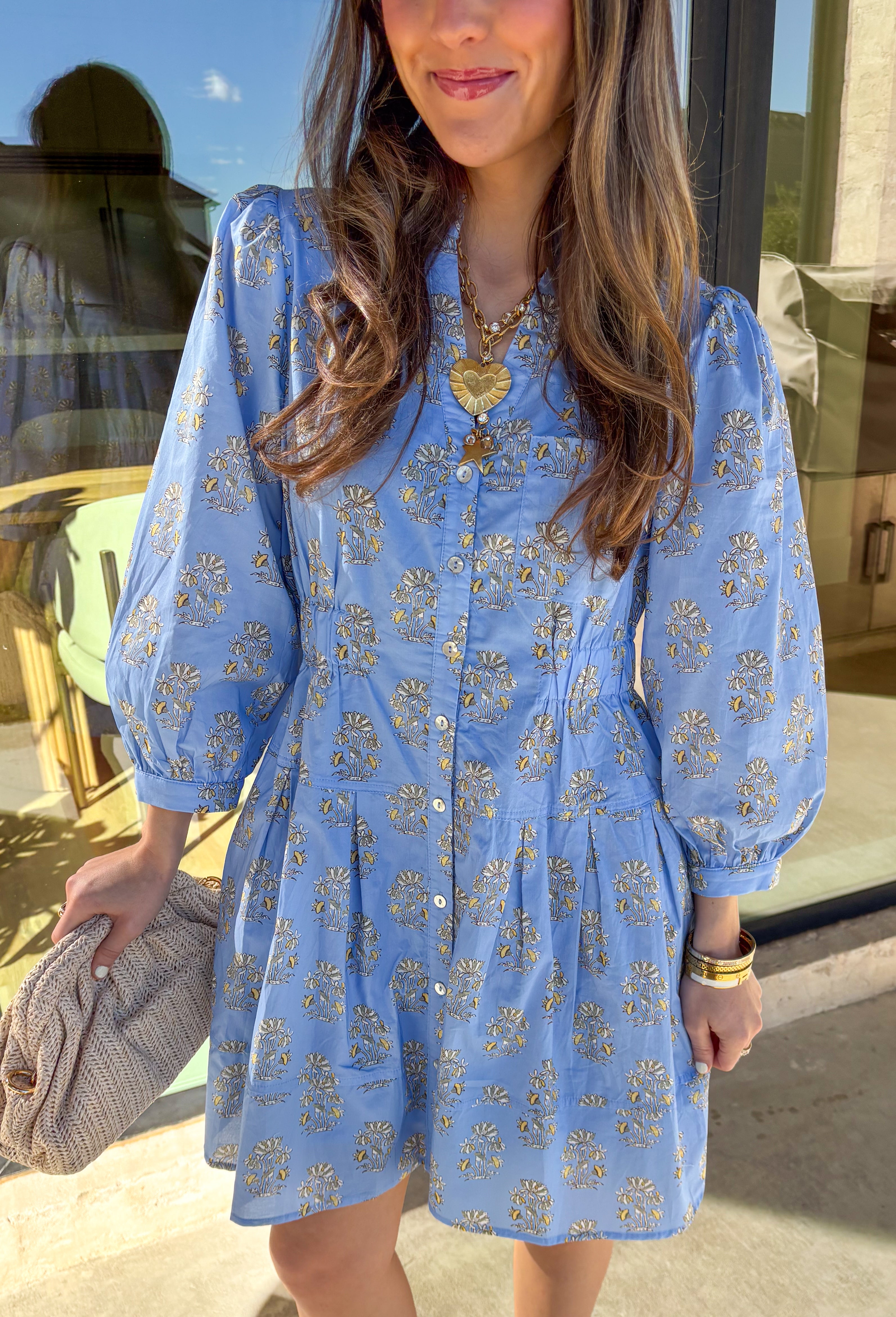Soft, feminine, and made for spring days, this light blue long sleeve dress by Entro is the kind of piece you’ll reach for when you want to feel effortlessly put together. Featuring a floral print throughout, it brings a fresh pop of color while still feeling classic and easy to wear. Smocking at the waist creates a flattering shape without sacrificing comfort, and the front pocket detail adds a casual, laid-back touch. Finished with side pockets and a fully lined cotton feel, this dress is perfect for brun