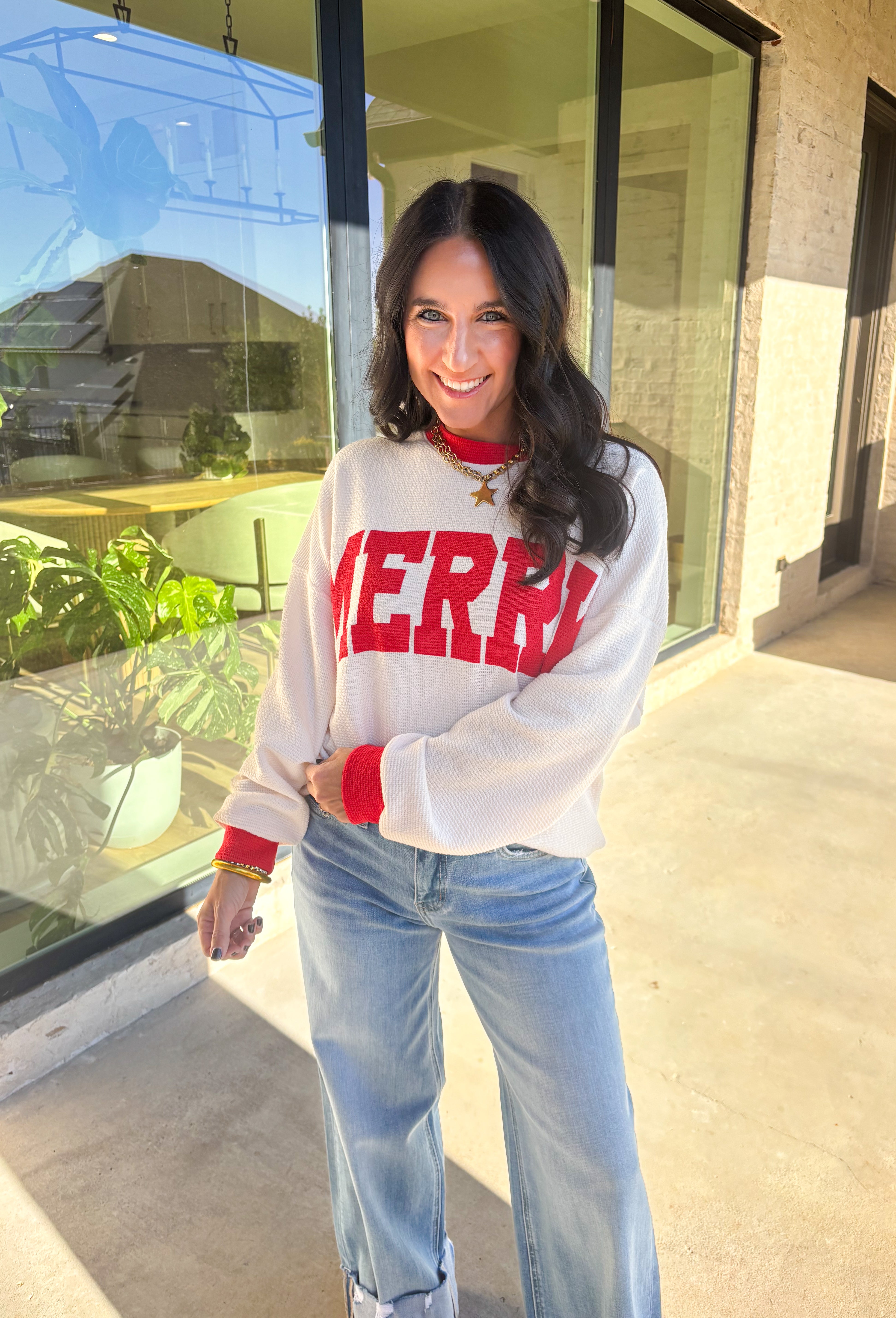 Get into the holiday spirit with this cheerful off-white pullover by Tres Bien! Featuring bold red “Merry” lettering and matching red trim along the neckline, sleeves, and hem, this cozy oversized pullover is pure festive fun. Soft, comfy, and perfect for pairing with your favorite jeans or leggings, it’s made for cookie baking, movie marathons, and all your merry moments this season.