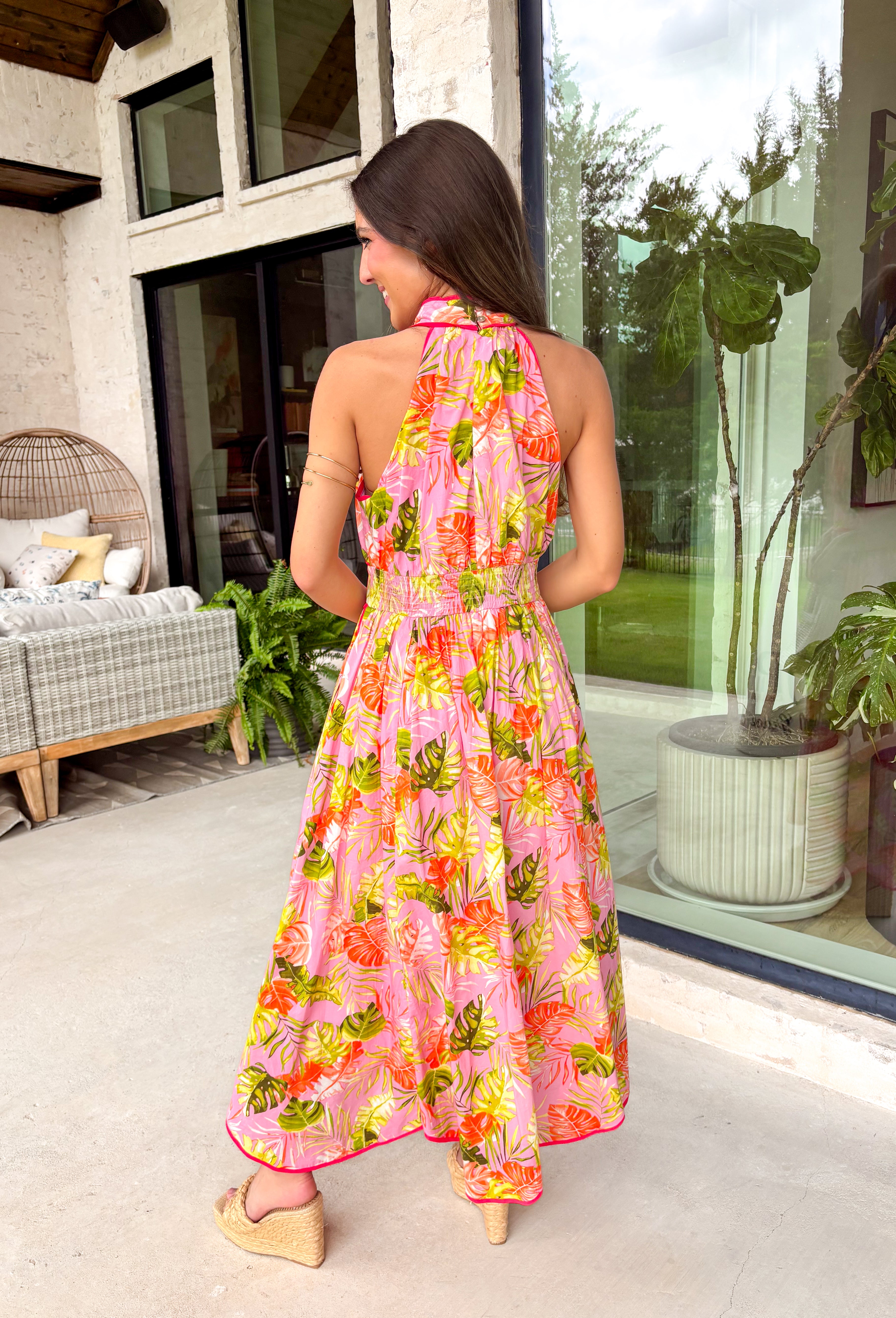 This pink botanical midi dress is such a fresh and vibrant pick for summer! The colorful print adds the perfect pop of personality, while the mock neckline gives it a slightly elevated, polished feel. Designed with a smocked back waist, it offers a flattering and comfortable fit that moves with you throughout the day. Fully lined and made from breathable cotton, it’s perfect for everything from brunch to special events. The button-loop closure at the back adds a delicate finishing touch. 