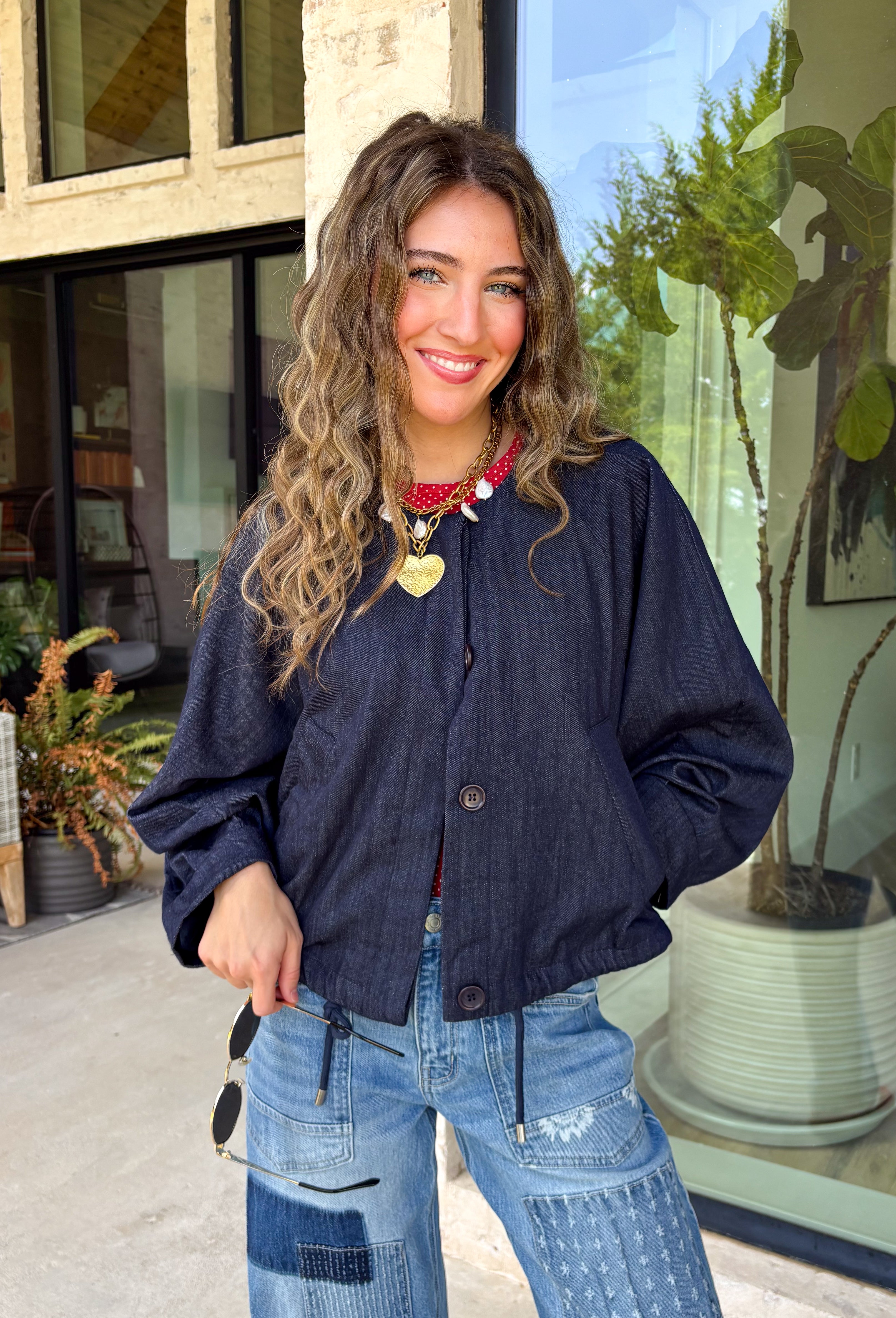 Meet the lightweight jacket you'll be reaching for all season long. Designed in a versatile navy hue, this timeless layering piece combines effortless style with everyday functionality. The button-front design and adjustable drawstring waist create a flattering, customizable fit, while the front pockets add the perfect finishing touch for keeping your essentials close. 