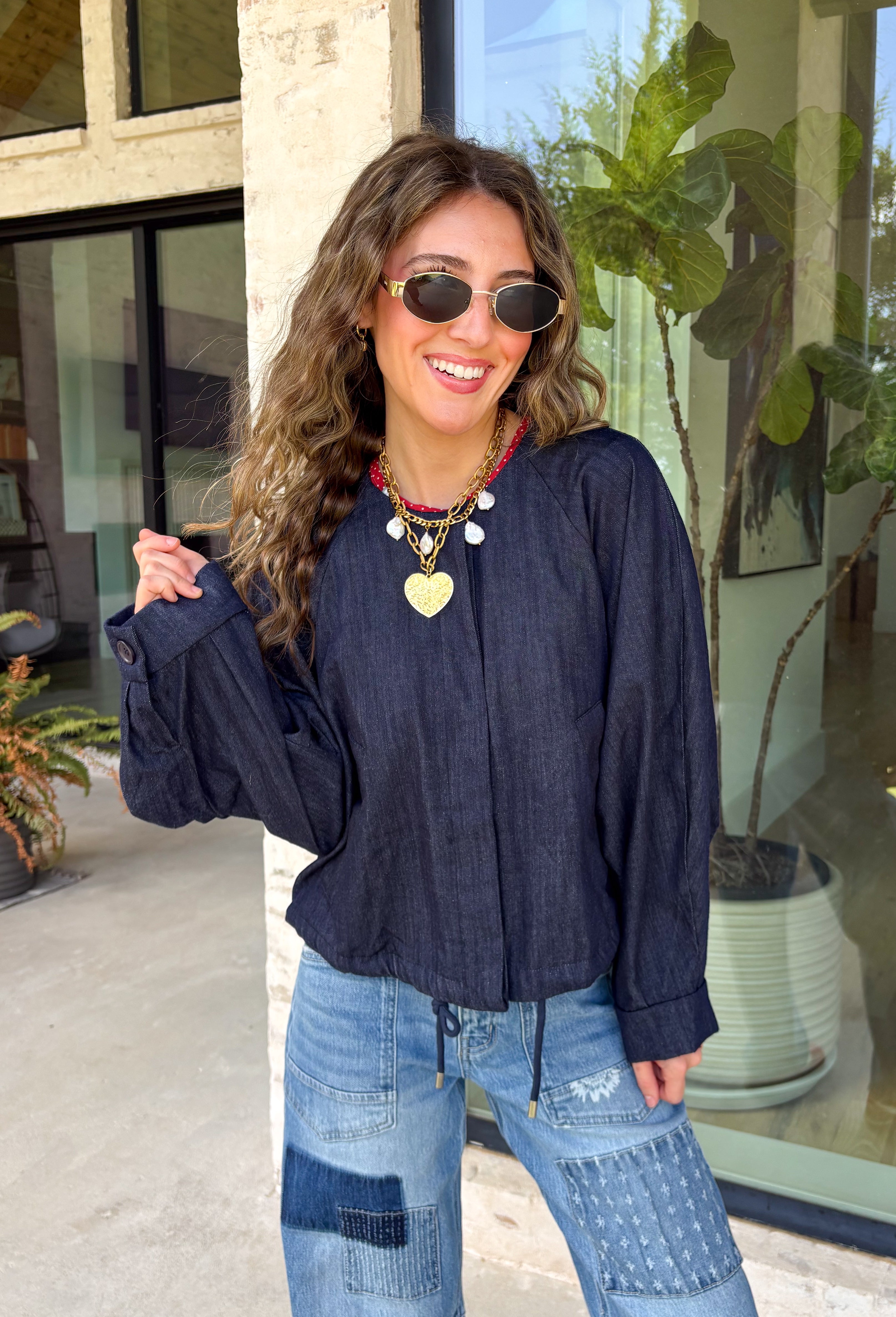 Meet the lightweight jacket you'll be reaching for all season long. Designed in a versatile navy hue, this timeless layering piece combines effortless style with everyday functionality. The button-front design and adjustable drawstring waist create a flattering, customizable fit, while the front pockets add the perfect finishing touch for keeping your essentials close. 