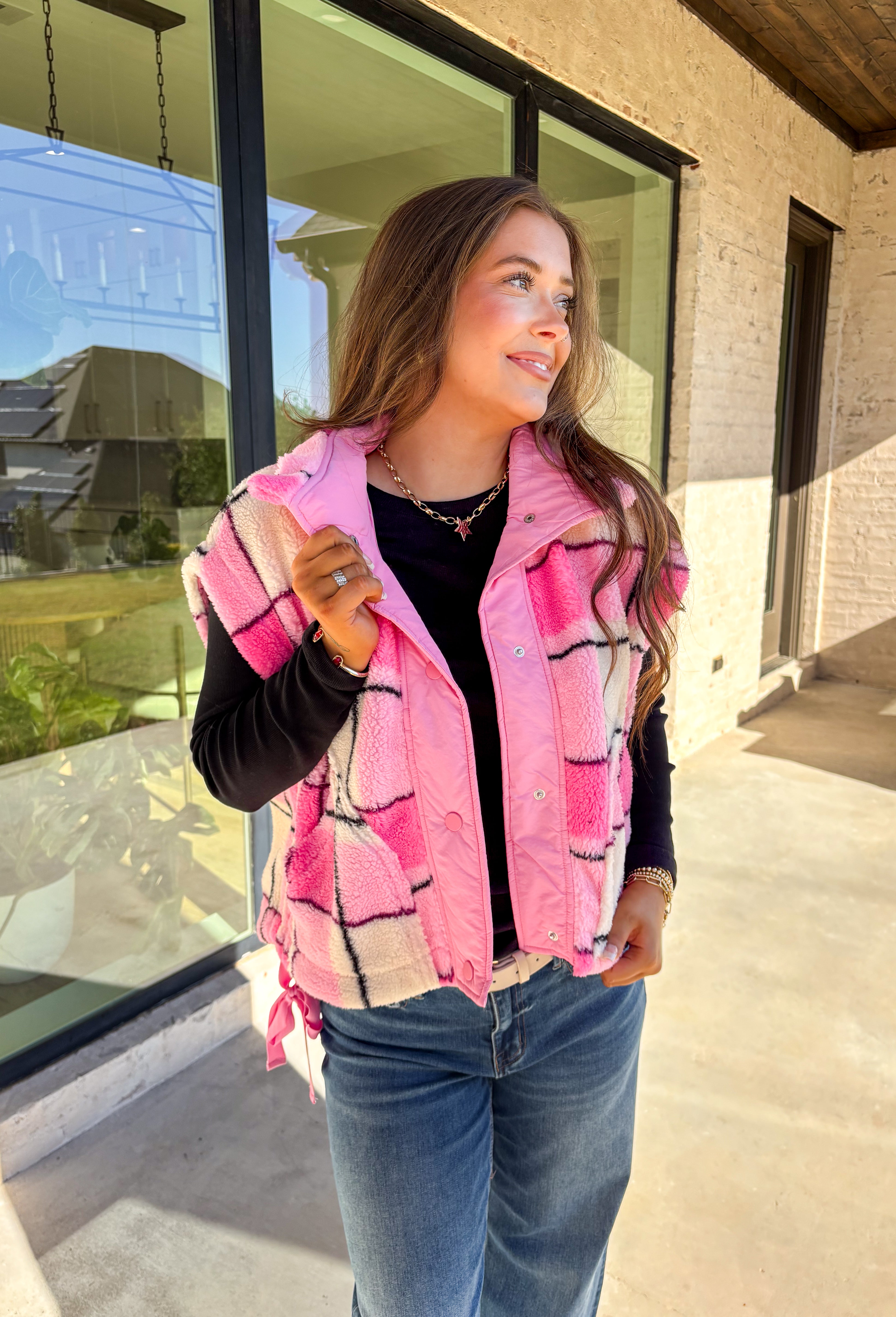 Get bundled up in cuteness with this cozy pink and white plaid vest! With sweet pops of black in the pattern and darling pink bow ties on each side, it brings just the right amount of charm to your cold-weather wardrobe. Whether you're layering it over a long sleeve tee or a chunky knit sweater, this vest is ready to warm things up in the coziest way.