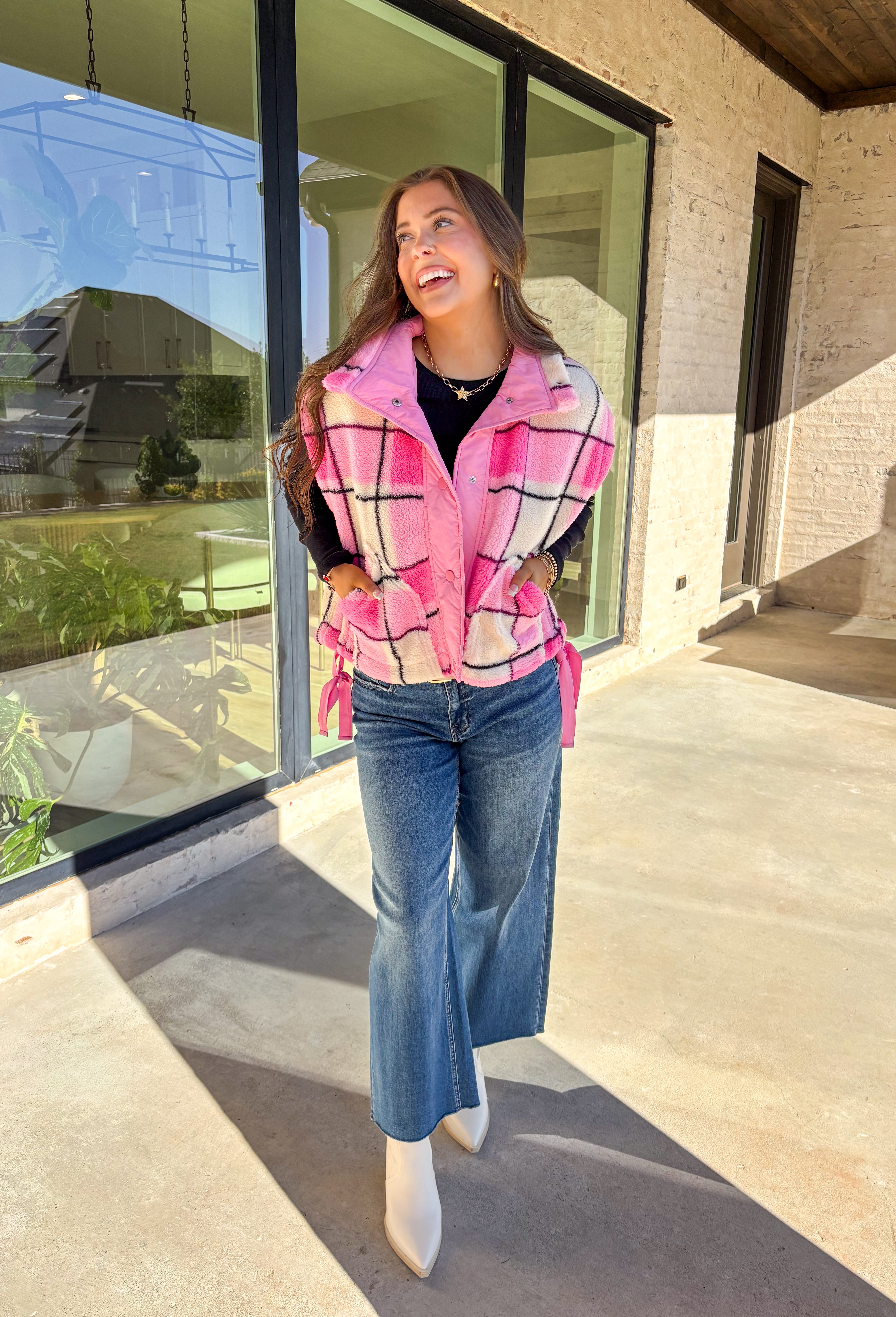 Get bundled up in cuteness with this cozy pink and white plaid vest! With sweet pops of black in the pattern and darling pink bow ties on each side, it brings just the right amount of charm to your cold-weather wardrobe. Whether you're layering it over a long sleeve tee or a chunky knit sweater, this vest is ready to warm things up in the coziest way.