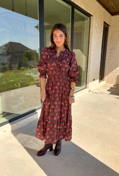 Soft and romantic, this brown midi dress is sprinkled with a neutral floral print accented by pops of red for a seasonal touch. The smocked waist gives it a flattering fit, while the tiered skirt and elastic sleeves keep the silhouette flowy and comfortable. Made from breathable cotton and designed with feminine details, this dress is a versatile piece you can style casually for daytime or dress up for fall gatherings.