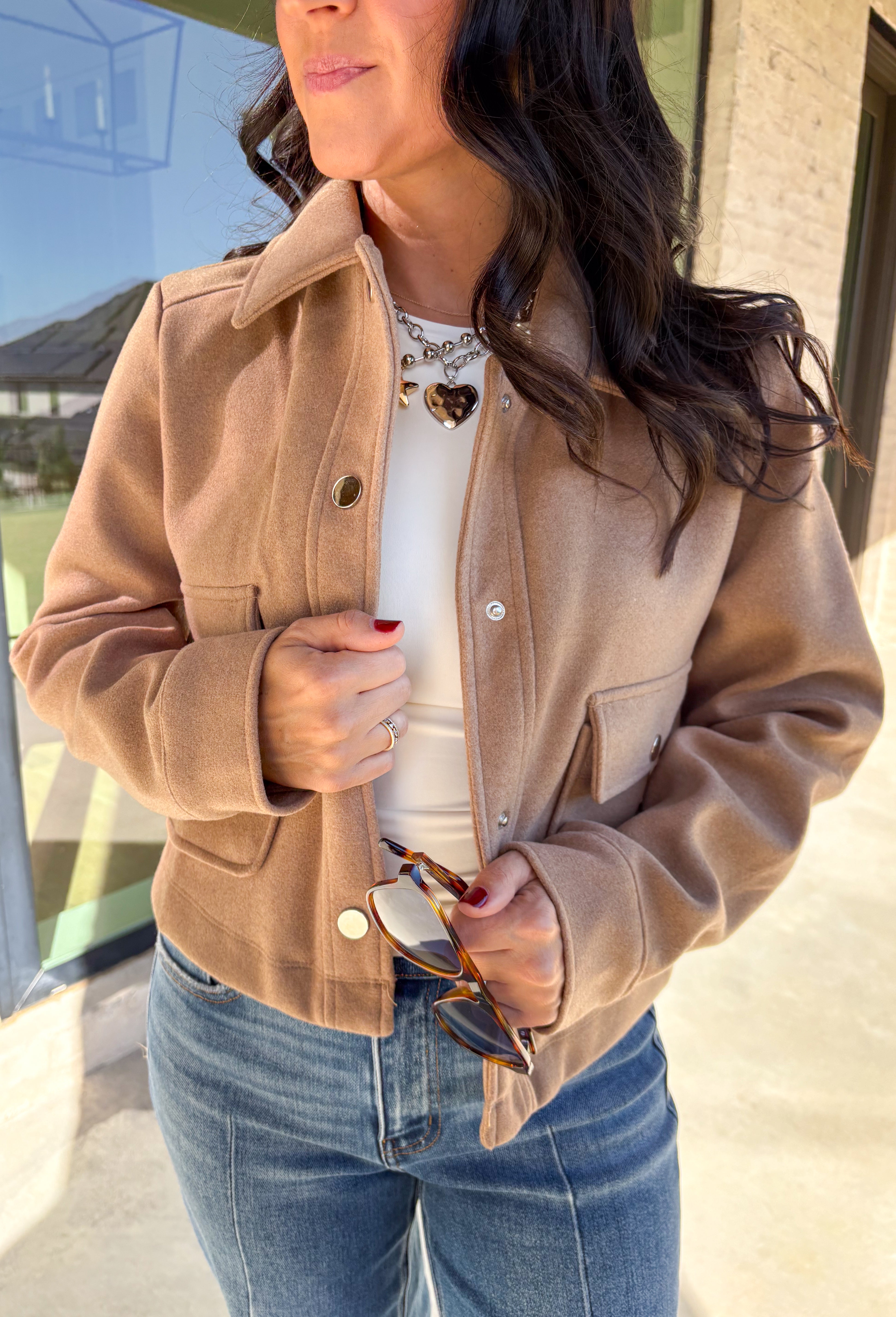A timeless staple with everyday versatility, this light taupe jacket by Blashe is perfect for layering through the season. Designed with a collared neckline, silver snap button closures, and two front pockets, it balances utility with modern style. Lightweight yet cozy, it’s an easy throw-on piece that works just as well over dresses as it does with denim.