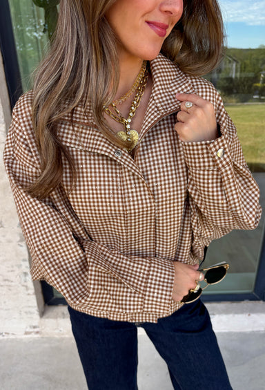 Classic gingham gets a fun fall refresh with this camel and cream jacket from Glam. The neutral checkered print keeps it easy to style, while sequin stitching throughout adds just the right amount of sparkle when it catches the light. A collared neckline and both zipper and button closures give it a structured, jacket-inspired look, while the elastic back hem creates a comfortable shape.