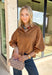 Elevate your everyday wardrobe with this effortlessly polished faux suede top from Day + Moon. Designed in a warm camel hue, this timeless button-down blouse is the perfect blend of classic style and seasonal charm. The collared neckline gives it a refined look, while the soft balloon sleeves add just the right amount of feminine flair. Crafted from buttery-soft faux suede, this versatile top easily transitions from the office to weekend outings, making it a staple you'll reach for all fall long.