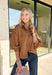 Elevate your everyday wardrobe with this effortlessly polished faux suede top from Day + Moon. Designed in a warm camel hue, this timeless button-down blouse is the perfect blend of classic style and seasonal charm. The collared neckline gives it a refined look, while the soft balloon sleeves add just the right amount of feminine flair. Crafted from buttery-soft faux suede, this versatile top easily transitions from the office to weekend outings, making it a staple you'll reach for all fall long.