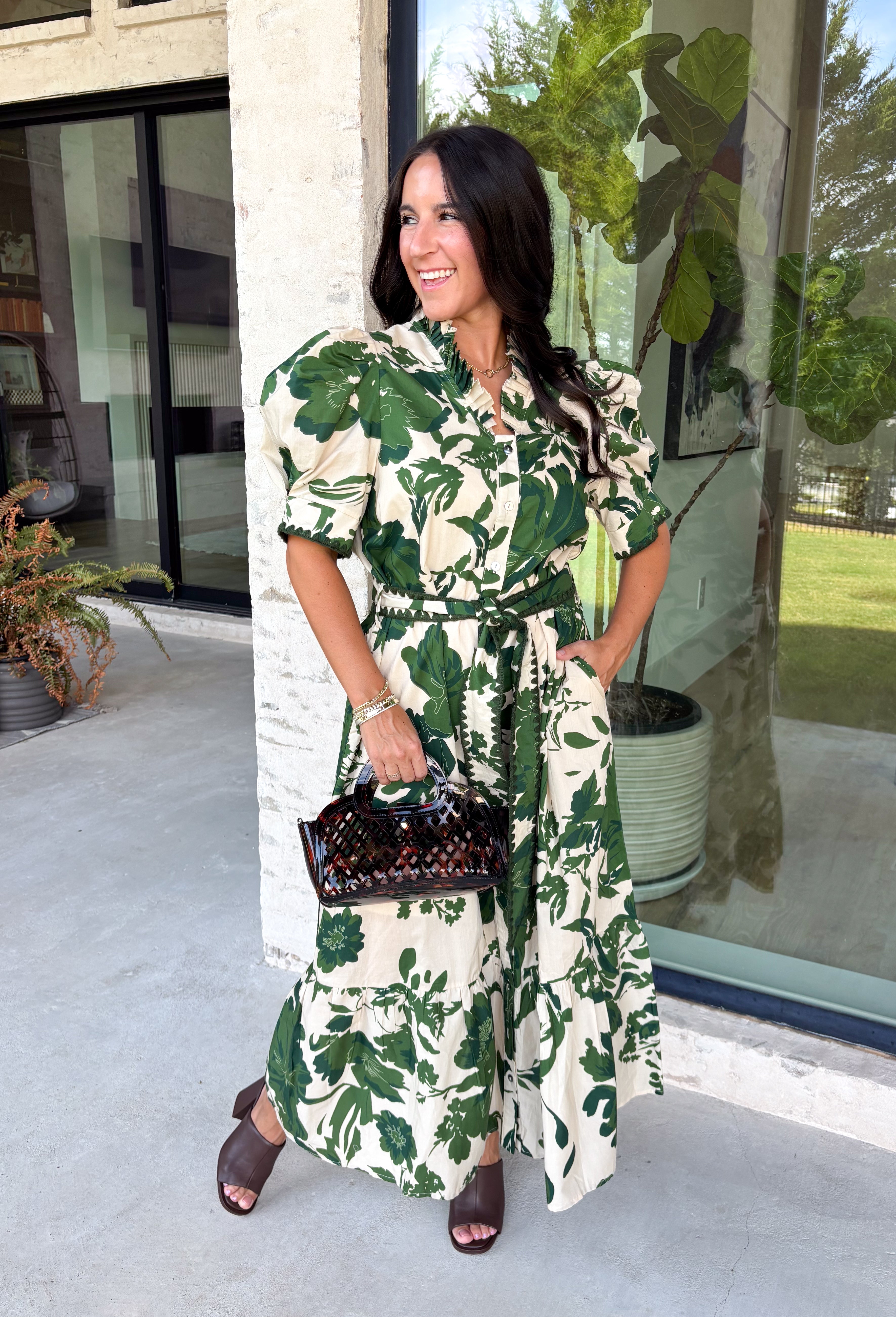 Classic florals and thoughtful details make this midi dress a standout for the season. Designed with a soft cream backdrop and an olive floral print, this beautifully feminine dress is perfect for everything from brunch dates to family gatherings. Delicate pleating along the neckline and collar adds elegant texture, while the matching self-tie belt creates a flattering, customizable silhouette. 