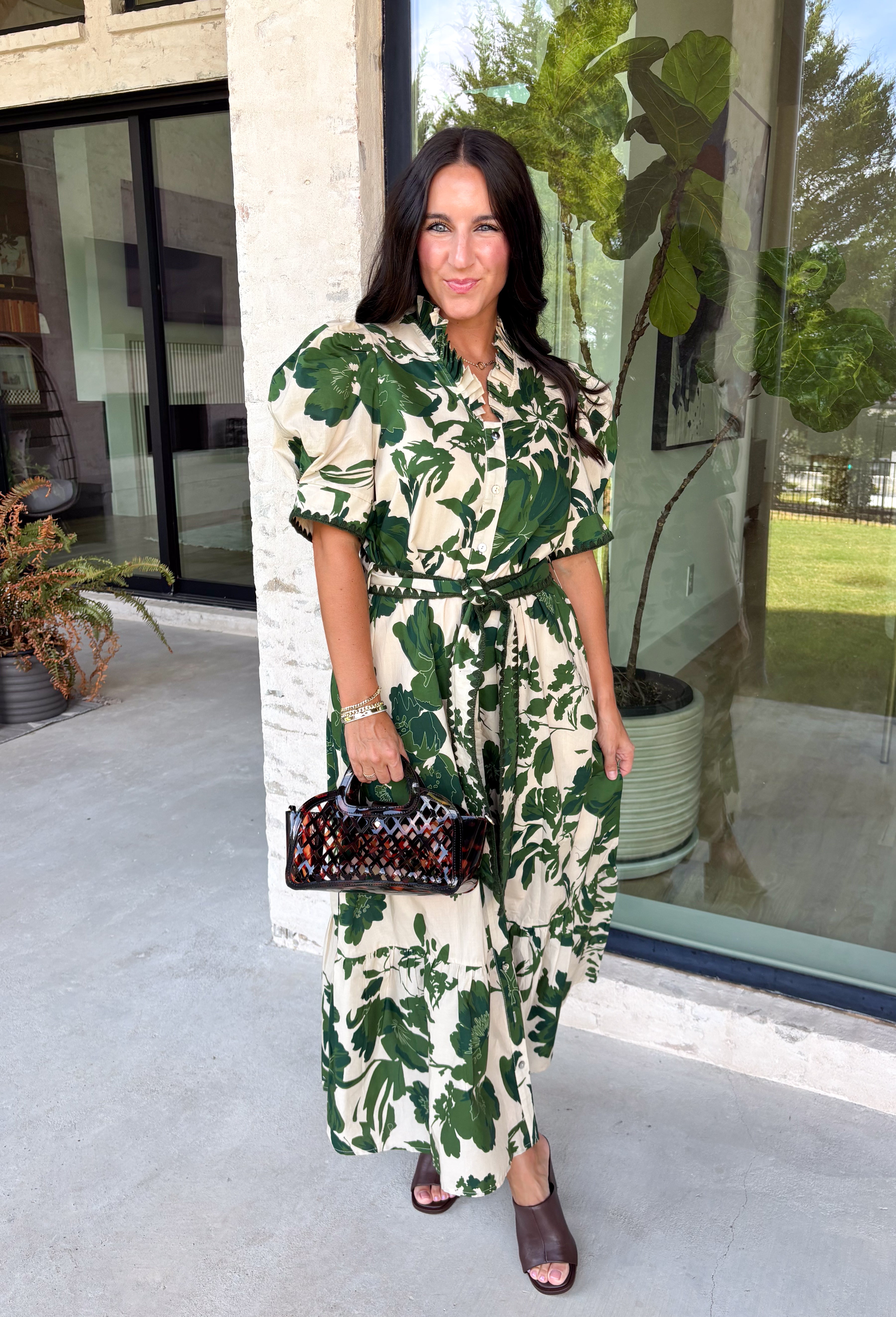 Classic florals and thoughtful details make this midi dress a standout for the season. Designed with a soft cream backdrop and an olive floral print, this beautifully feminine dress is perfect for everything from brunch dates to family gatherings. Delicate pleating along the neckline and collar adds elegant texture, while the matching self-tie belt creates a flattering, customizable silhouette. 