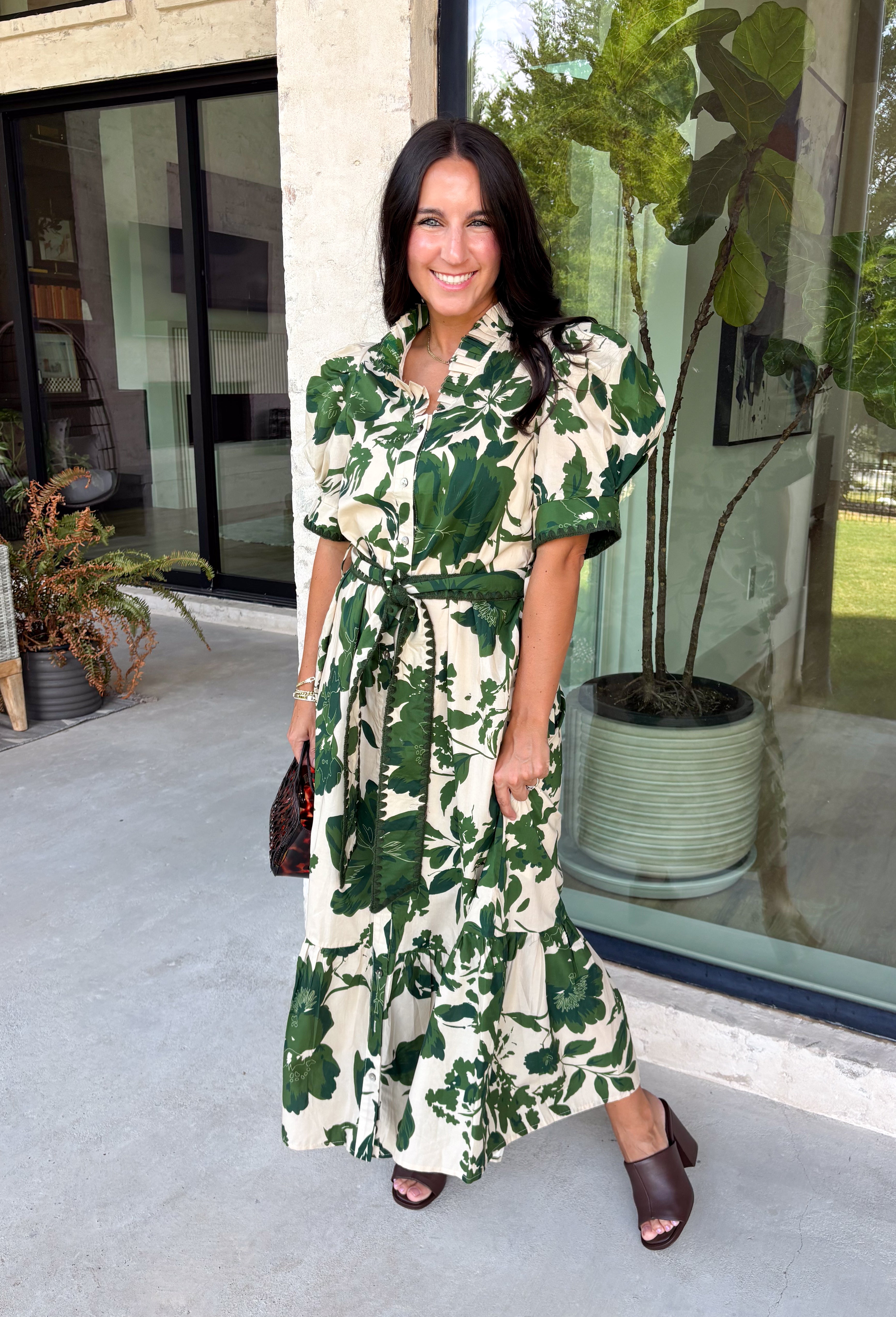 Classic florals and thoughtful details make this midi dress a standout for the season. Designed with a soft cream backdrop and an olive floral print, this beautifully feminine dress is perfect for everything from brunch dates to family gatherings. Delicate pleating along the neckline and collar adds elegant texture, while the matching self-tie belt creates a flattering, customizable silhouette. 