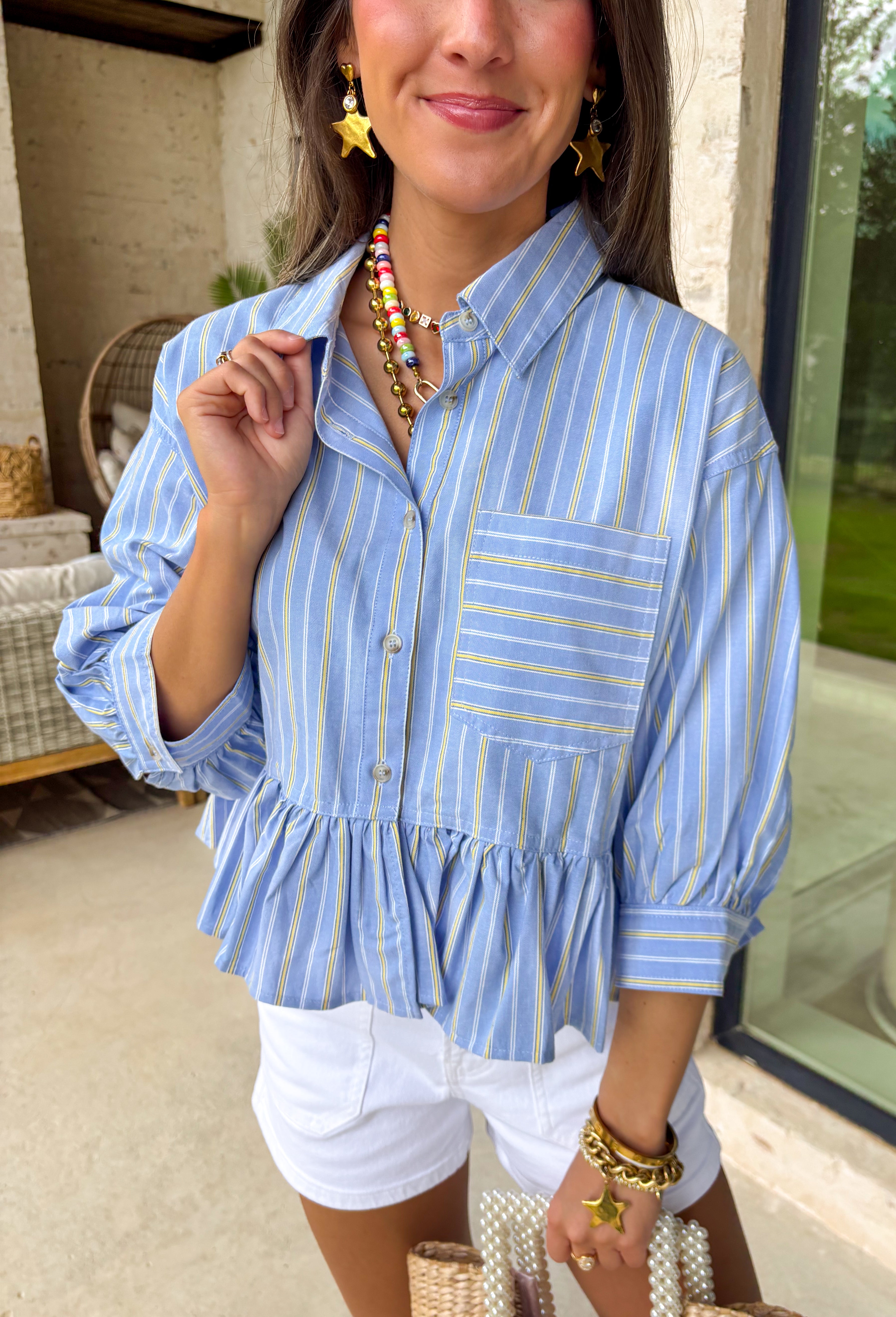 This light blue babydoll top is basically spring in outfit form! With soft pale yellow and white stripes, a classic collared neckline, and a button-down front, it’s the perfect mix of polished and playful. The babydoll silhouette gives you that easy, floaty fit we all love—cute, comfy, and made for sunny days. Finished with a sweet ruffle hem, it’s the kind of top you’ll throw on with denim shorts, white jeans for an effortless, breezy look.