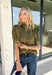 A timeless polka dot print meets feminine details in this effortlessly polished top from Entro. Designed in a rich olive hue with crisp white polka dot accents, this top is perfect for elevating your everyday wardrobe. The ruffled high neckline adds a refined touch, while the button-front closure and contrast cuffs create a beautifully tailored finish. Puff sleeves and button cuffs complete the look, making this versatile blouse an easy choice for everything from workdays to weekend outings.