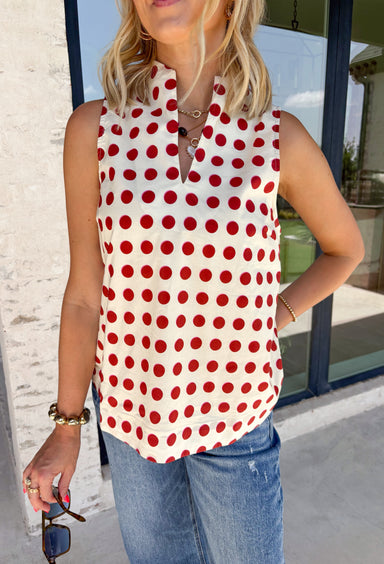 Add a touch of playful charm to your everyday wardrobe with this effortlessly polished sleeveless top from Entro. Featuring a soft ecru backdrop with a rust polka dot print and subtle pops of pink, this lightweight blouse is full of warm seasonal color. The flattering v-neckline keeps the look timeless, while the pleated back detail adds beautiful movement and an easy, flowy fit. 