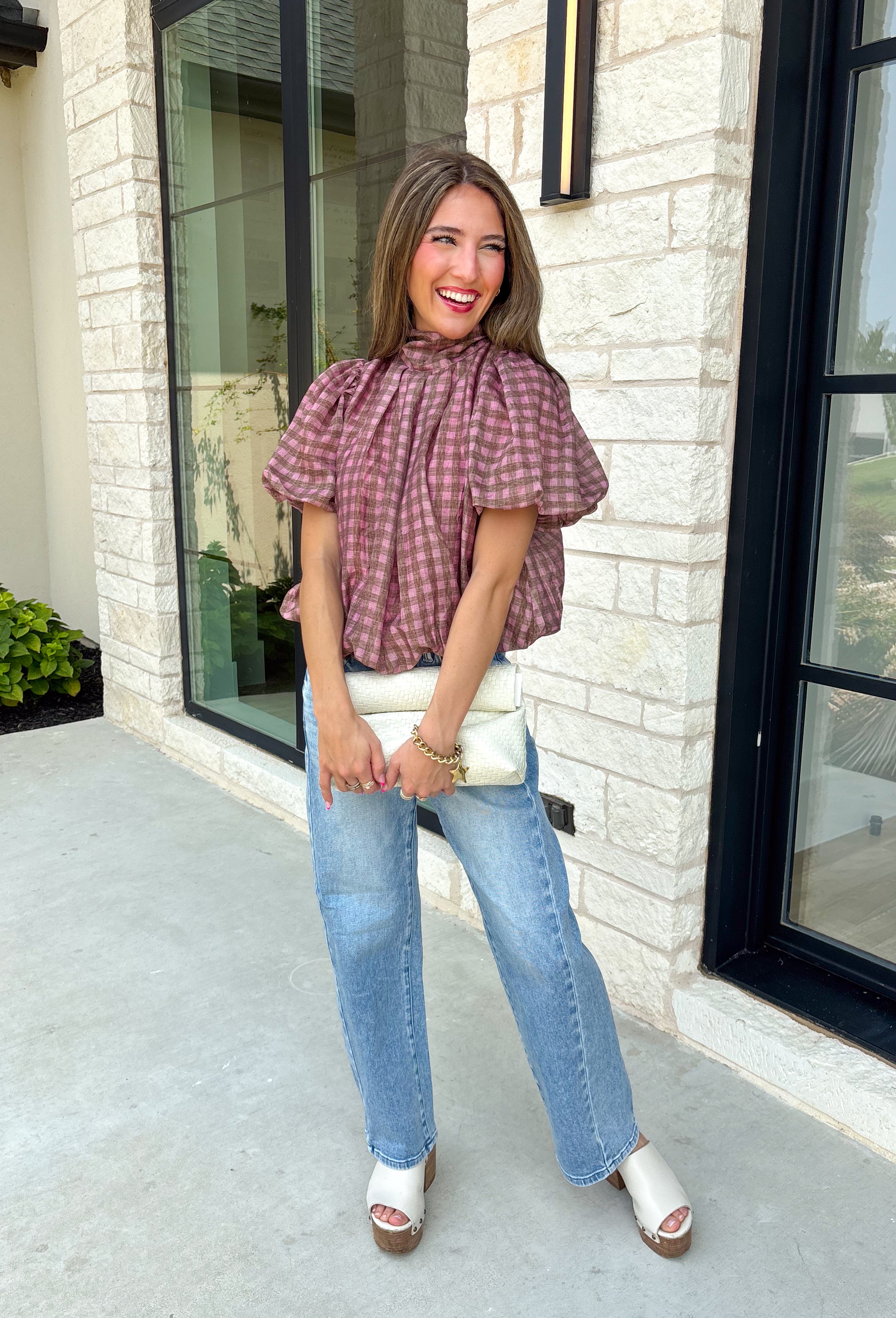 Sweet gingham and thoughtful details make this blouse an instant favorite for the season. Featuring a charming pink and brown gingham print, this lightweight top brings a fresh, feminine touch to your fall wardrobe. The mock neckline with a tie detail at the neck, puff sleeves, and bubble hem create a flattering silhouette that's both polished and comfortable. 