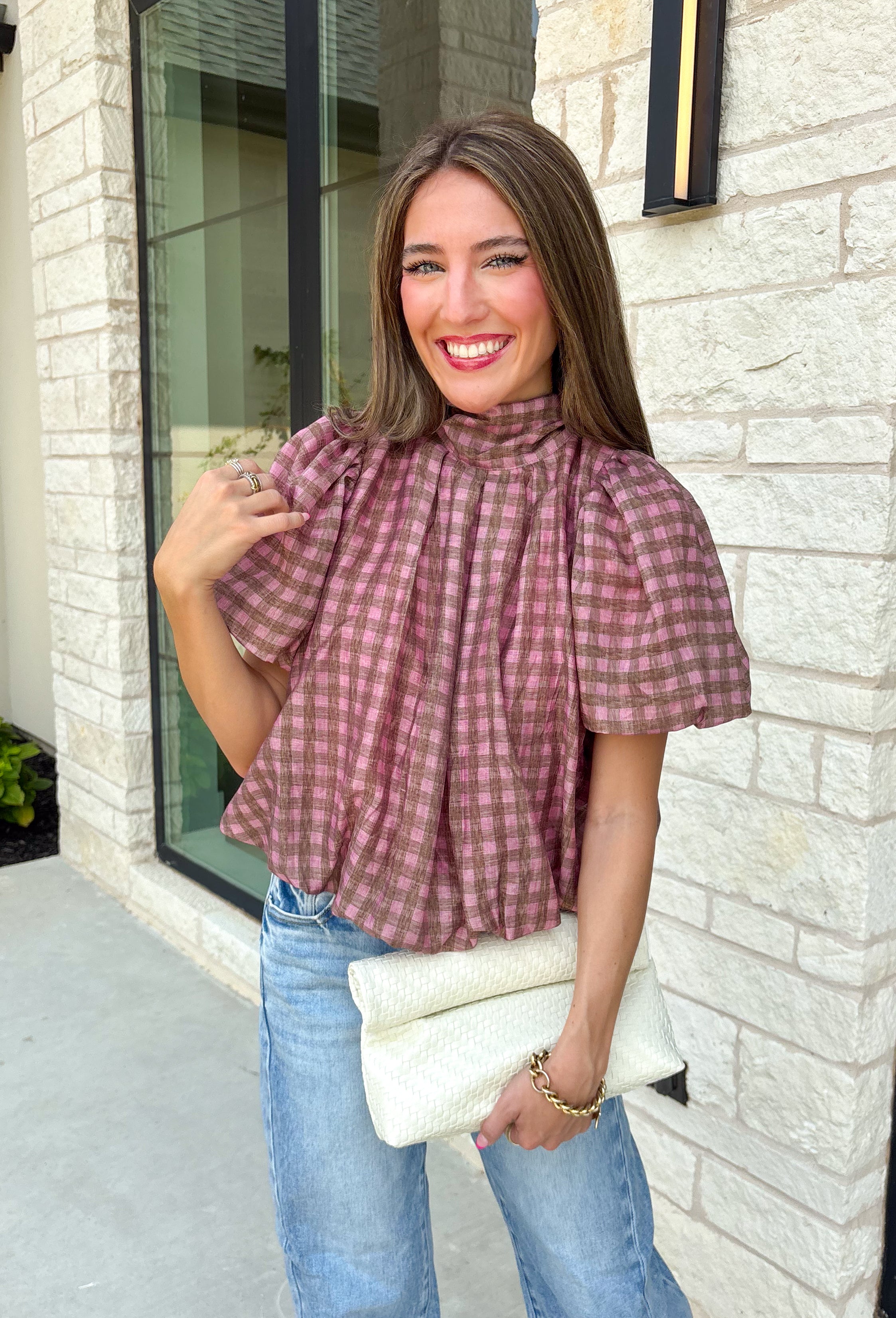 Sweet gingham and thoughtful details make this blouse an instant favorite for the season. Featuring a charming pink and brown gingham print, this lightweight top brings a fresh, feminine touch to your fall wardrobe. The mock neckline with a tie detail at the neck, puff sleeves, and bubble hem create a flattering silhouette that's both polished and comfortable. 