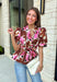 A beautiful floral blouse is one of those pieces you'll reach for all season long, and this one is full of thoughtful details you'll love! Designed with a soft neutral background, this feminine top is adorned with rich brown and pink florals accented by subtle pops of black for the perfect autumn-inspired palette. The flattering self-tie waist creates a customizable silhouette, while the smocked back offers a comfortable fit that moves with you throughout the day.