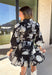This black floral dress by Entro is a timeless favorite with a touch of charm. Designed with an off-white and gray floral print, it features ¾ puff sleeves, a button-front closure, and a flattering self-tie waist belt. The chest pocket adds a subtle utility touch, while the tiered ruffle hem and side pockets keep the look feminine and functional. This dress is perfect for any special occasion!