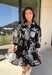 This black floral dress by Entro is a timeless favorite with a touch of charm. Designed with an off-white and gray floral print, it features ¾ puff sleeves, a button-front closure, and a flattering self-tie waist belt. The chest pocket adds a subtle utility touch, while the tiered ruffle hem and side pockets keep the look feminine and functional. This dress is perfect for any special occasion!