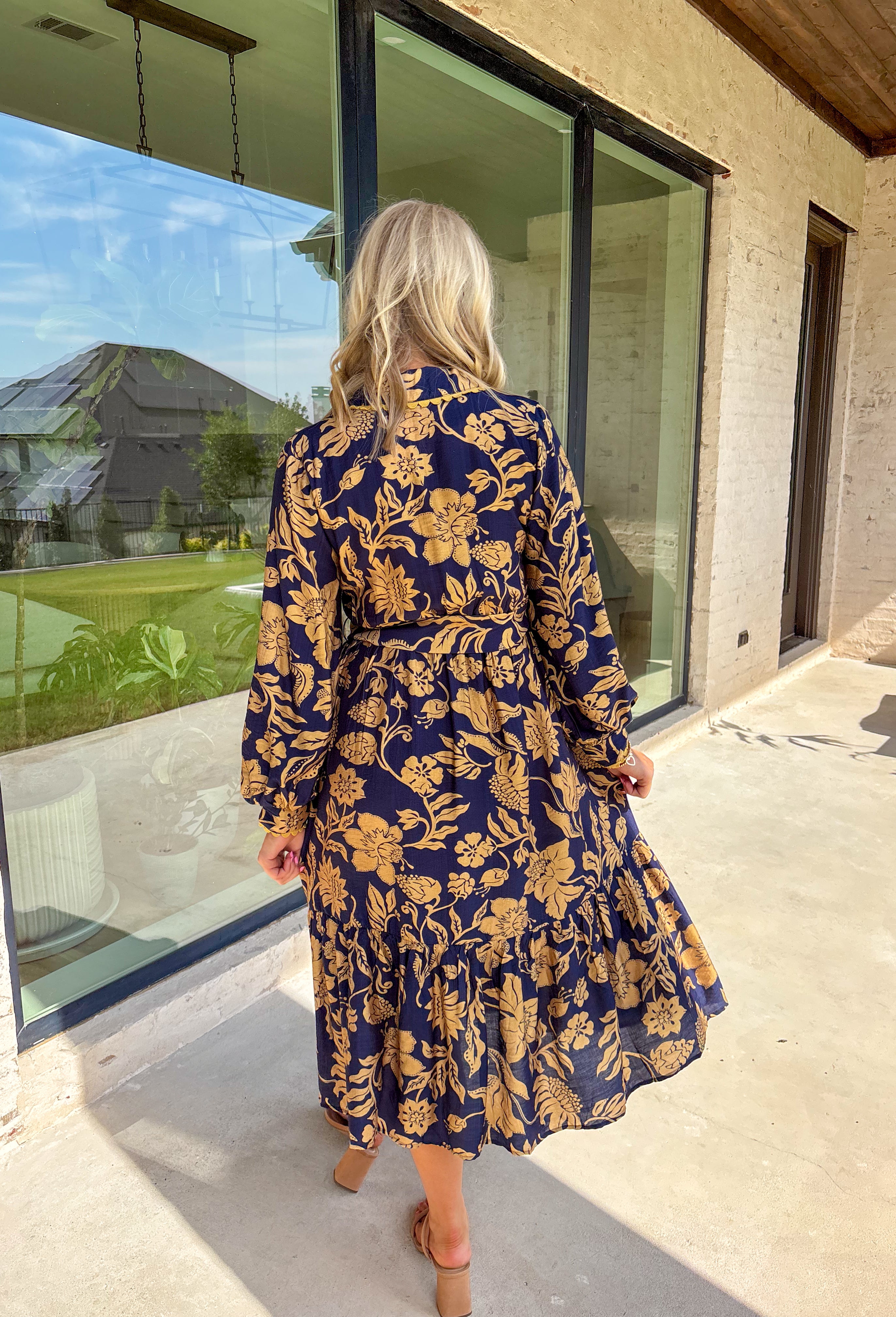 Moody florals meet timeless tailoring in this navy midi dress, patterned with an olive abstract floral print that’s perfect for fall. Scalloped trim along the front softens the look, while the collared neckline and button-down design keep it classic. Balloon sleeves add a hint of drama, and the self-tie waist lets you create a flattering, adjustable fit. Finished with a midi length for versatile styling, this piece is just as ready for weekday wear as it is for weekend outings.