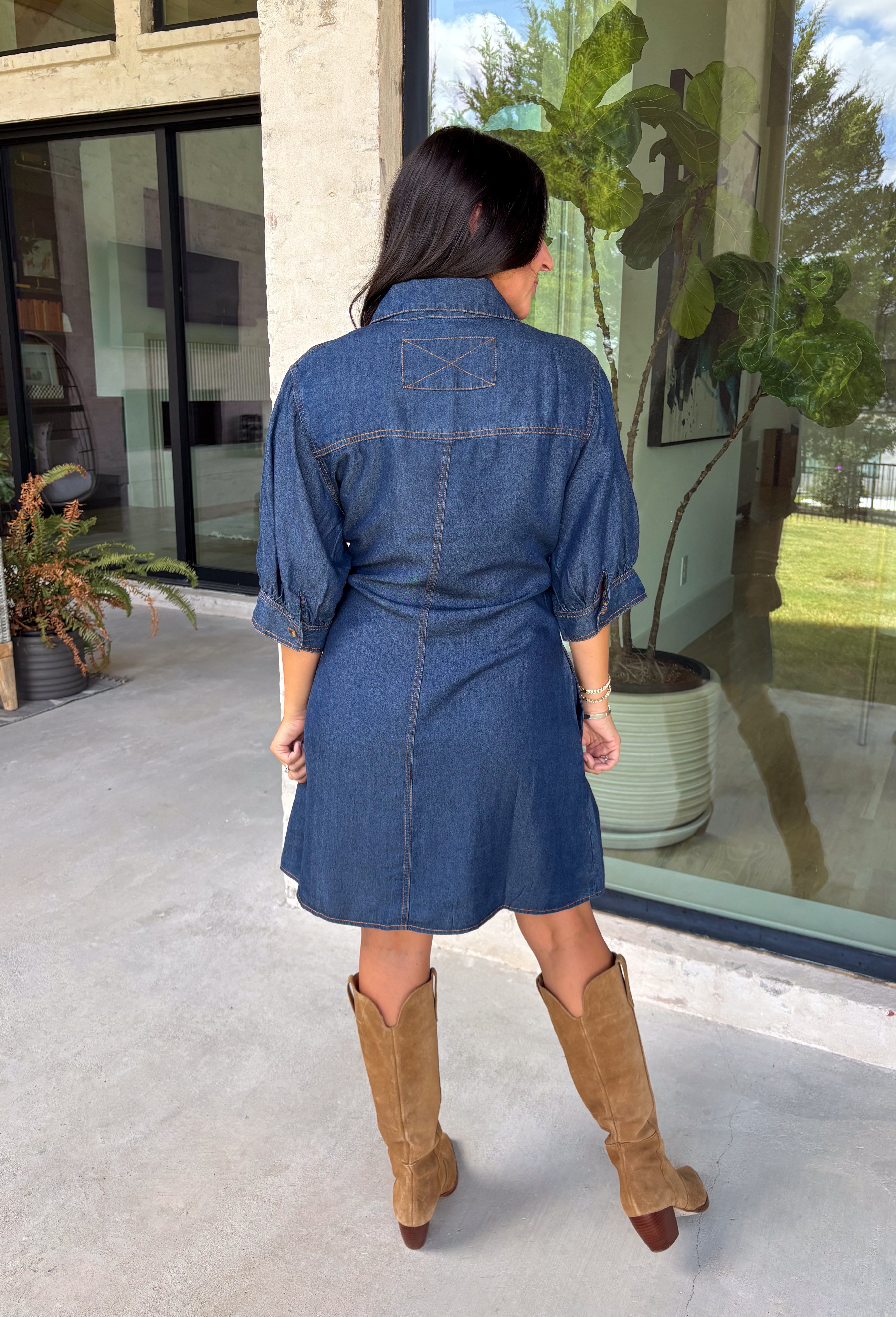 A timeless denim dress is always in style, and this lightweight beauty from Entro is one you'll wear on repeat. Crafted from soft medium wash tencel denim, this effortlessly flattering dress features a classic button-front design, a feminine v-neckline, and a matching self-tie waist that creates the perfect customizable fit. The ¾ length sleeves with button cuffs add a polished touch, while side pockets make it as practical as it is stylish. 