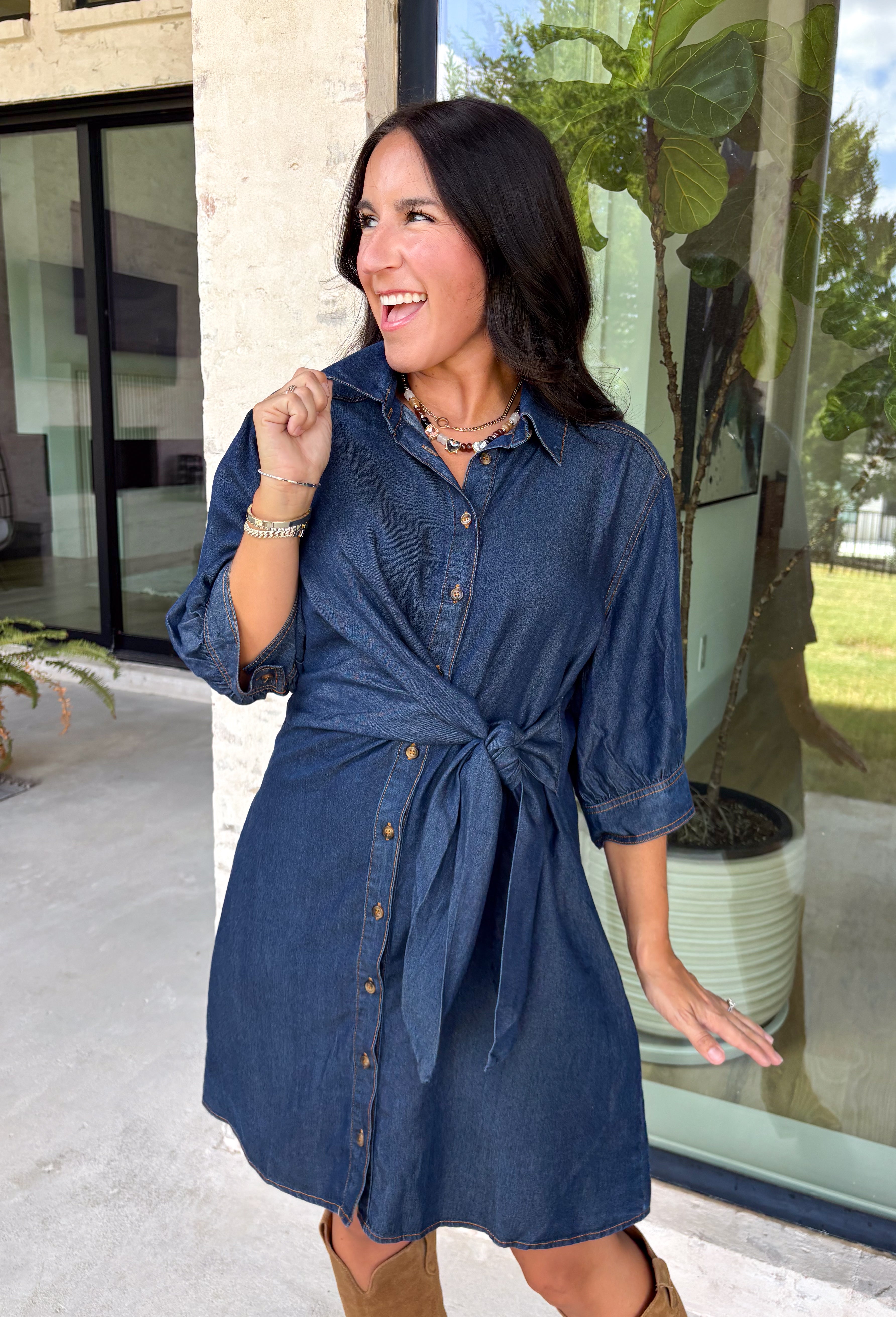 A timeless denim dress is always in style, and this lightweight beauty from Entro is one you'll wear on repeat. Crafted from soft medium wash tencel denim, this effortlessly flattering dress features a classic button-front design, a feminine v-neckline, and a matching self-tie waist that creates the perfect customizable fit. The ¾ length sleeves with button cuffs add a polished touch, while side pockets make it as practical as it is stylish. 