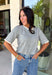 This grey short sleeve sweater is the perfect blend of cozy and classic for the fall season! The soft knit is beautifully finished with ivory scalloped trim along the neckline and sleeves, creating the look of an effortlessly layered outfit without any extra bulk. Its timeless silhouette makes it easy to style for work, weekend outings, or dinner with friends, while the lightweight knit is perfect for those crisp autumn days. 
