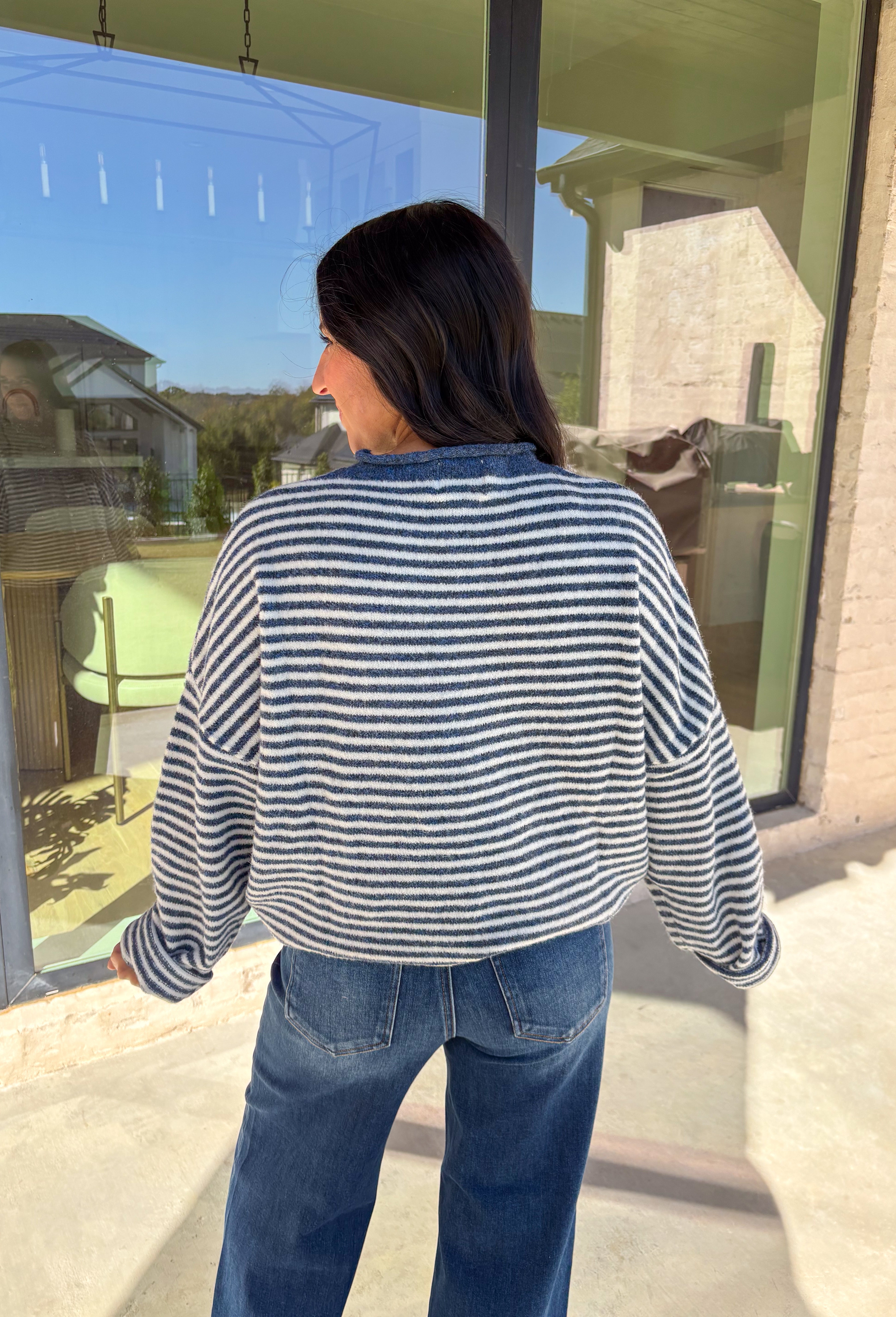 Classic stripes meet cozy comfort in this navy and white button-down cardigan by Things Between. Designed in a soft knit with a relaxed fit, this timeless piece brings effortless warmth to your winter wardrobe. The simple stripe pattern adds a touch of everyday charm, making it easy to style for layering through the colder months.