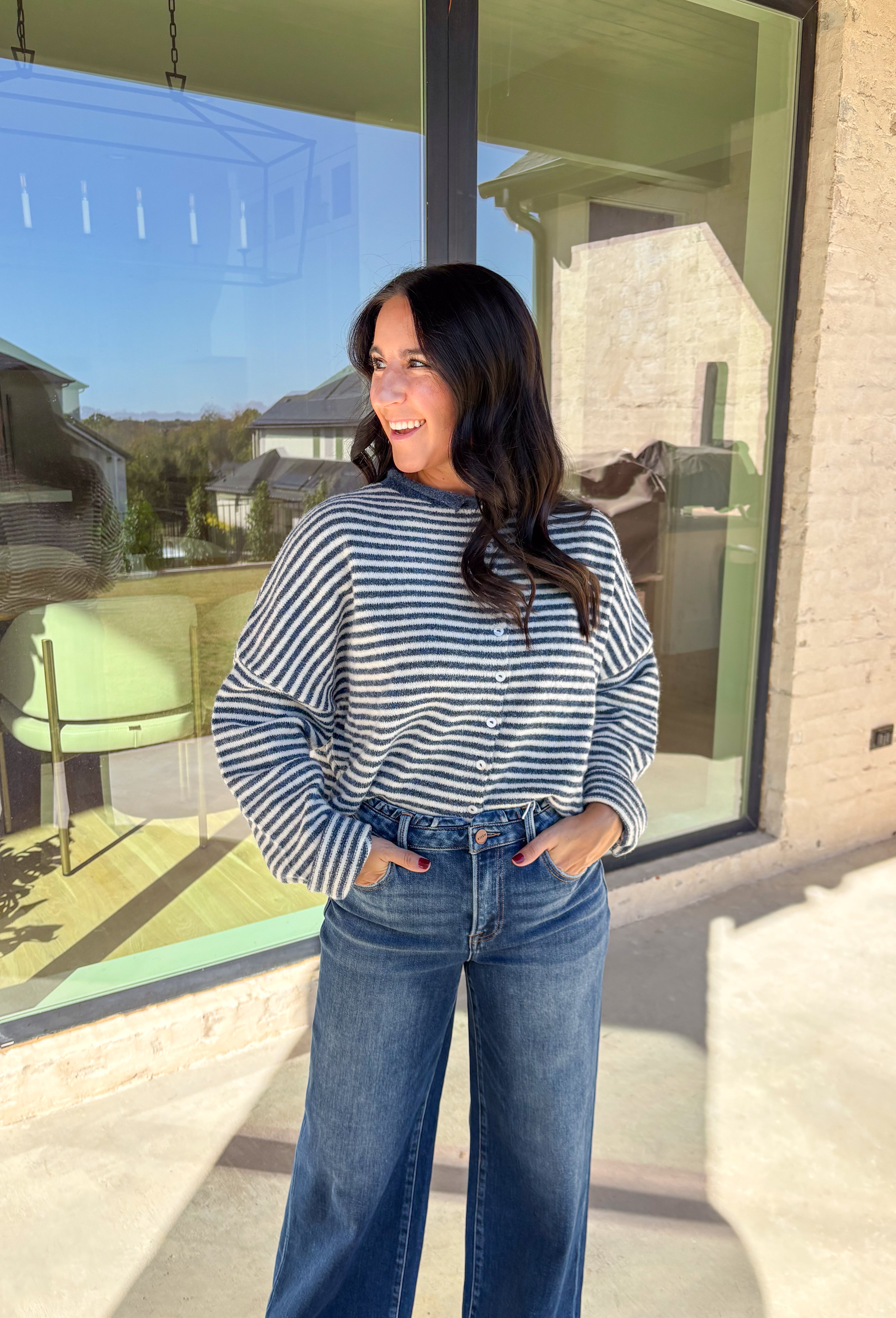 Classic stripes meet cozy comfort in this navy and white button-down cardigan by Things Between. Designed in a soft knit with a relaxed fit, this timeless piece brings effortless warmth to your winter wardrobe. The simple stripe pattern adds a touch of everyday charm, making it easy to style for layering through the colder months.