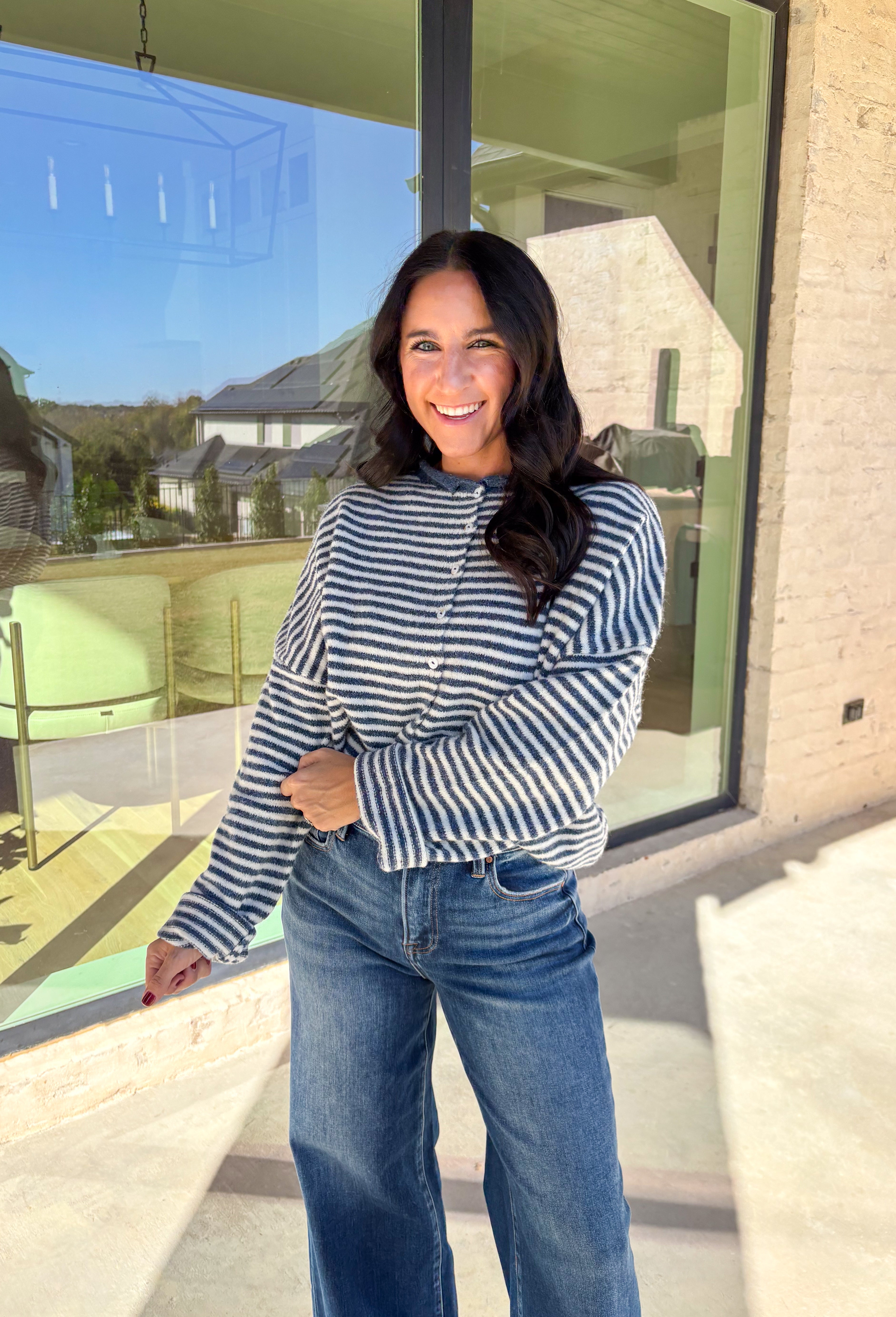 Classic stripes meet cozy comfort in this navy and white button-down cardigan by Things Between. Designed in a soft knit with a relaxed fit, this timeless piece brings effortless warmth to your winter wardrobe. The simple stripe pattern adds a touch of everyday charm, making it easy to style for layering through the colder months.