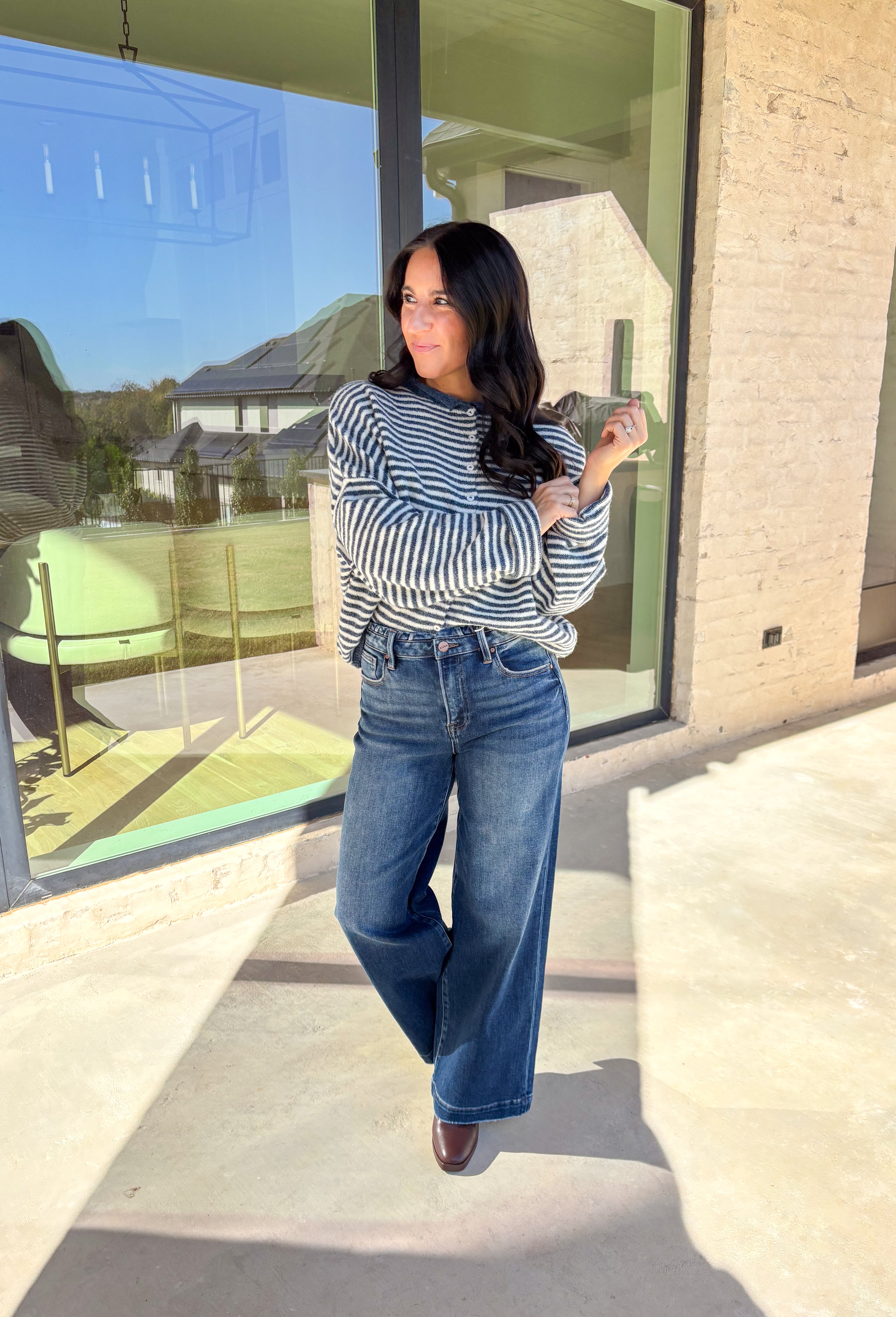 Classic stripes meet cozy comfort in this navy and white button-down cardigan by Things Between. Designed in a soft knit with a relaxed fit, this timeless piece brings effortless warmth to your winter wardrobe. The simple stripe pattern adds a touch of everyday charm, making it easy to style for layering through the colder months.