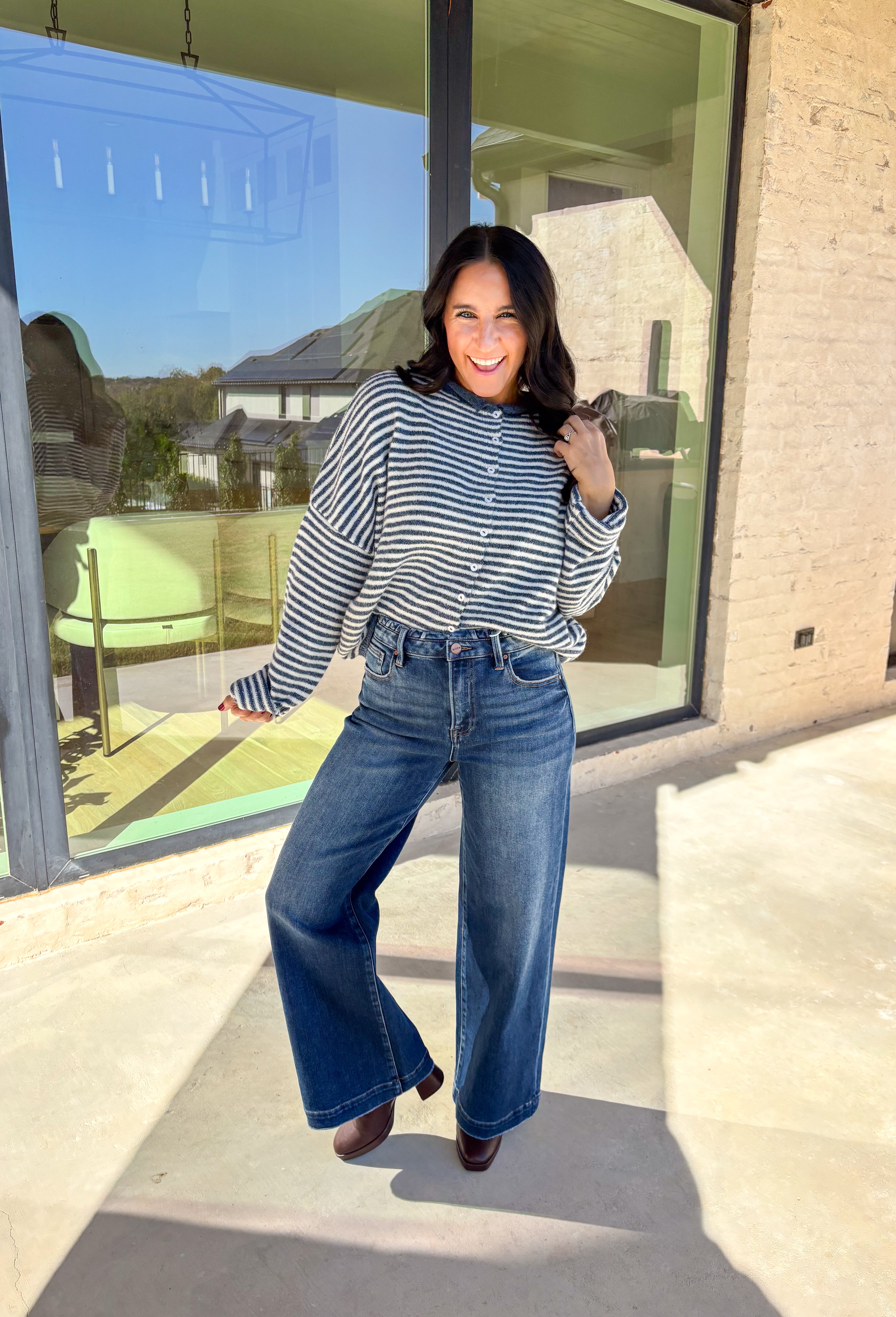 Classic stripes meet cozy comfort in this navy and white button-down cardigan by Things Between. Designed in a soft knit with a relaxed fit, this timeless piece brings effortless warmth to your winter wardrobe. The simple stripe pattern adds a touch of everyday charm, making it easy to style for layering through the colder months.