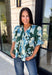 Bring a fresh take on fall florals to your wardrobe with this beautiful hunter green top. Featuring a delicate blue and off white floral print, this timeless top is perfect for everything from office days to weekend outings. The pintuck detailing along the front adds an elevated touch, while the button front and short puff sleeves create a feminine silhouette you'll love season after season. 