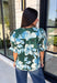 Bring a fresh take on fall florals to your wardrobe with this beautiful hunter green top. Featuring a delicate blue and off white floral print, this timeless top is perfect for everything from office days to weekend outings. The pintuck detailing along the front adds an elevated touch, while the button front and short puff sleeves create a feminine silhouette you'll love season after season. 